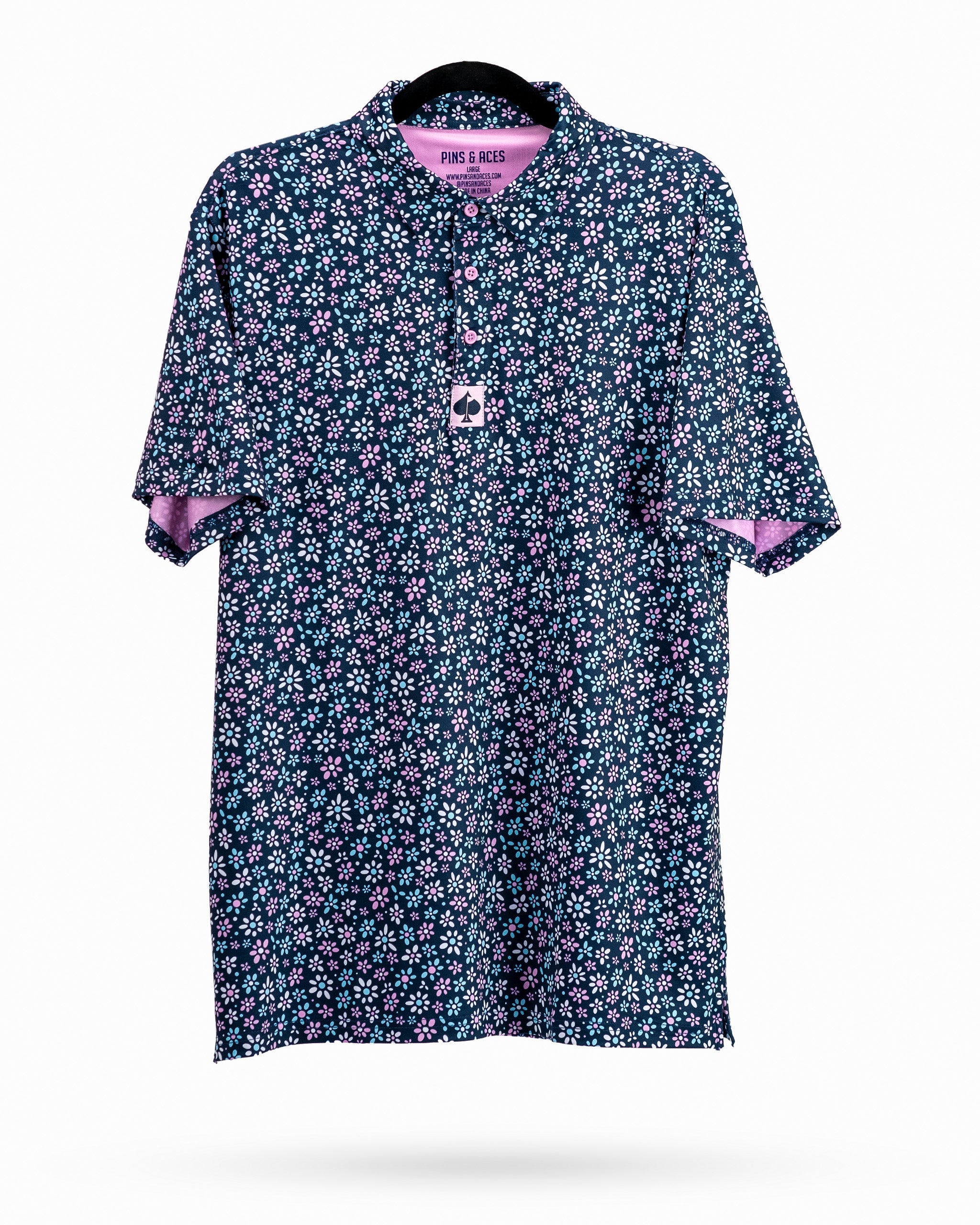 Navy golf polo shirt with a vibrant daisy print and pink accents, designed for stylish golfers.