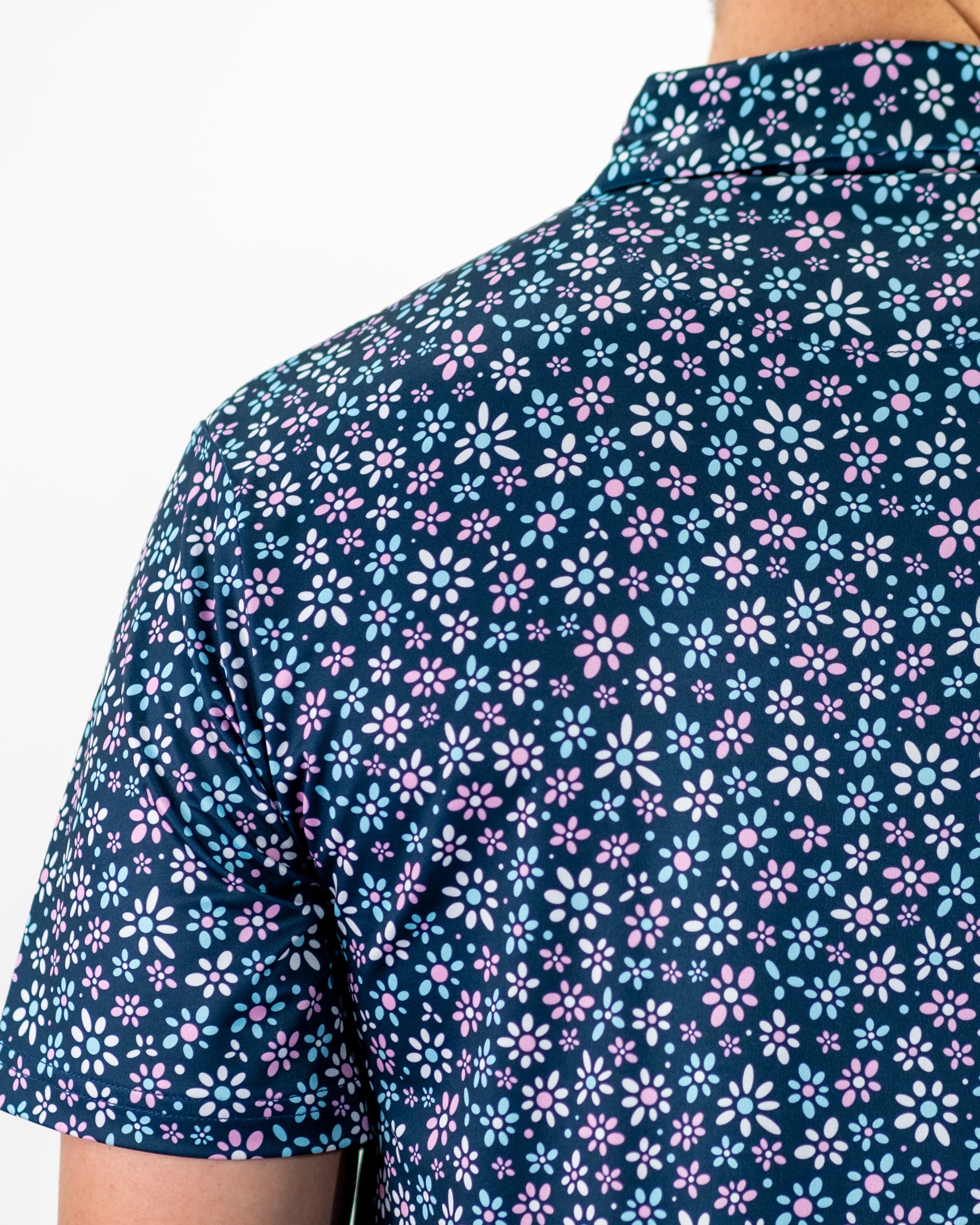 Men's golf shirt featuring a vibrant floral pattern in shades of pink and blue, perfect for a stylish day on the course.