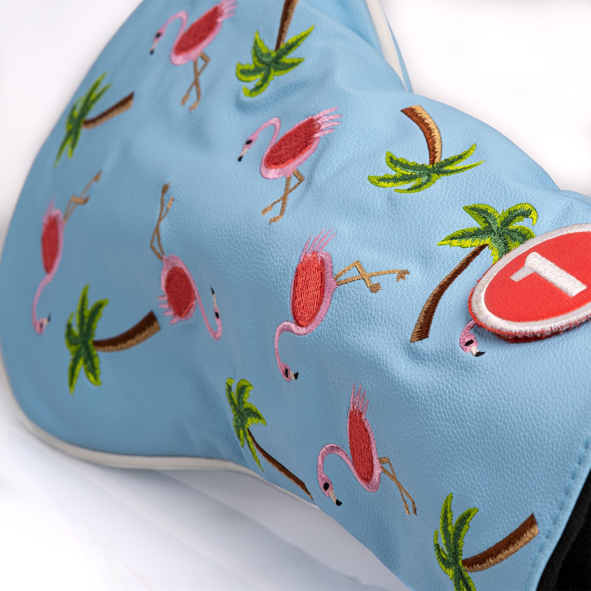 Colorful driver cover featuring embroidered dancing flamingos and palm trees on a light blue background.