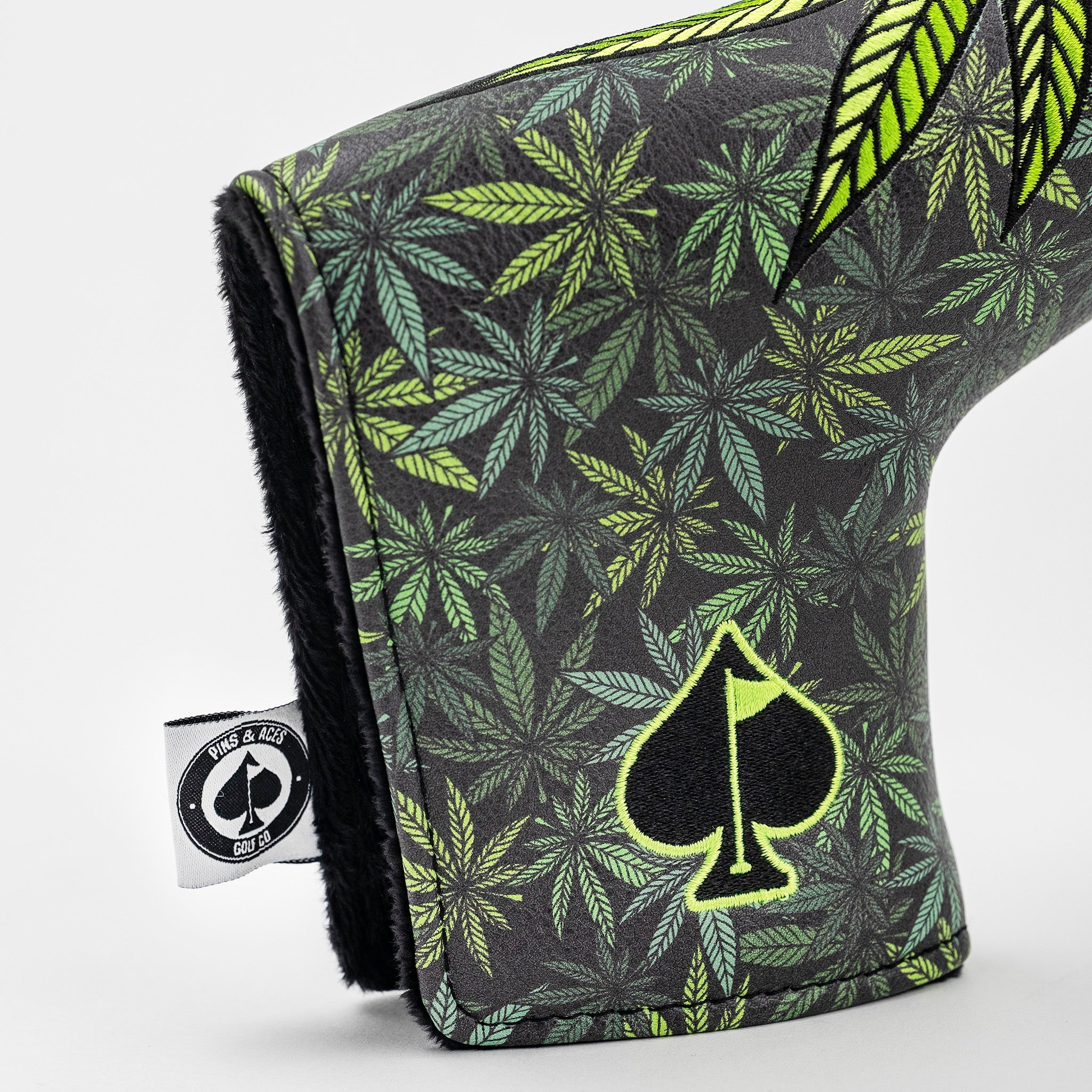 Bold blade putter cover featuring a vibrant leaf pattern and a distinctive logo, designed for high handicap golfers.