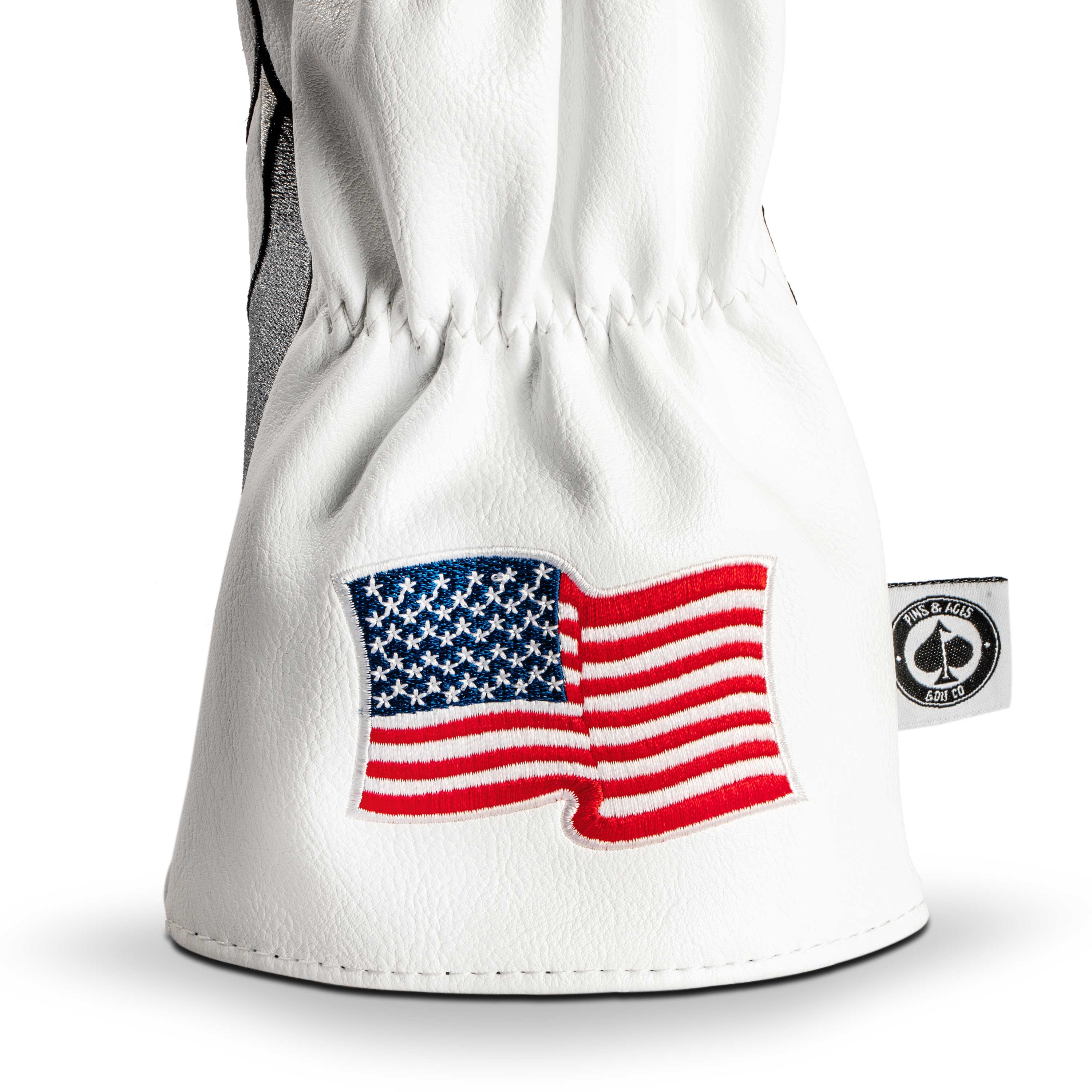 White driver cover featuring an embroidered American flag, designed for golfers seeking a bold and patriotic look.