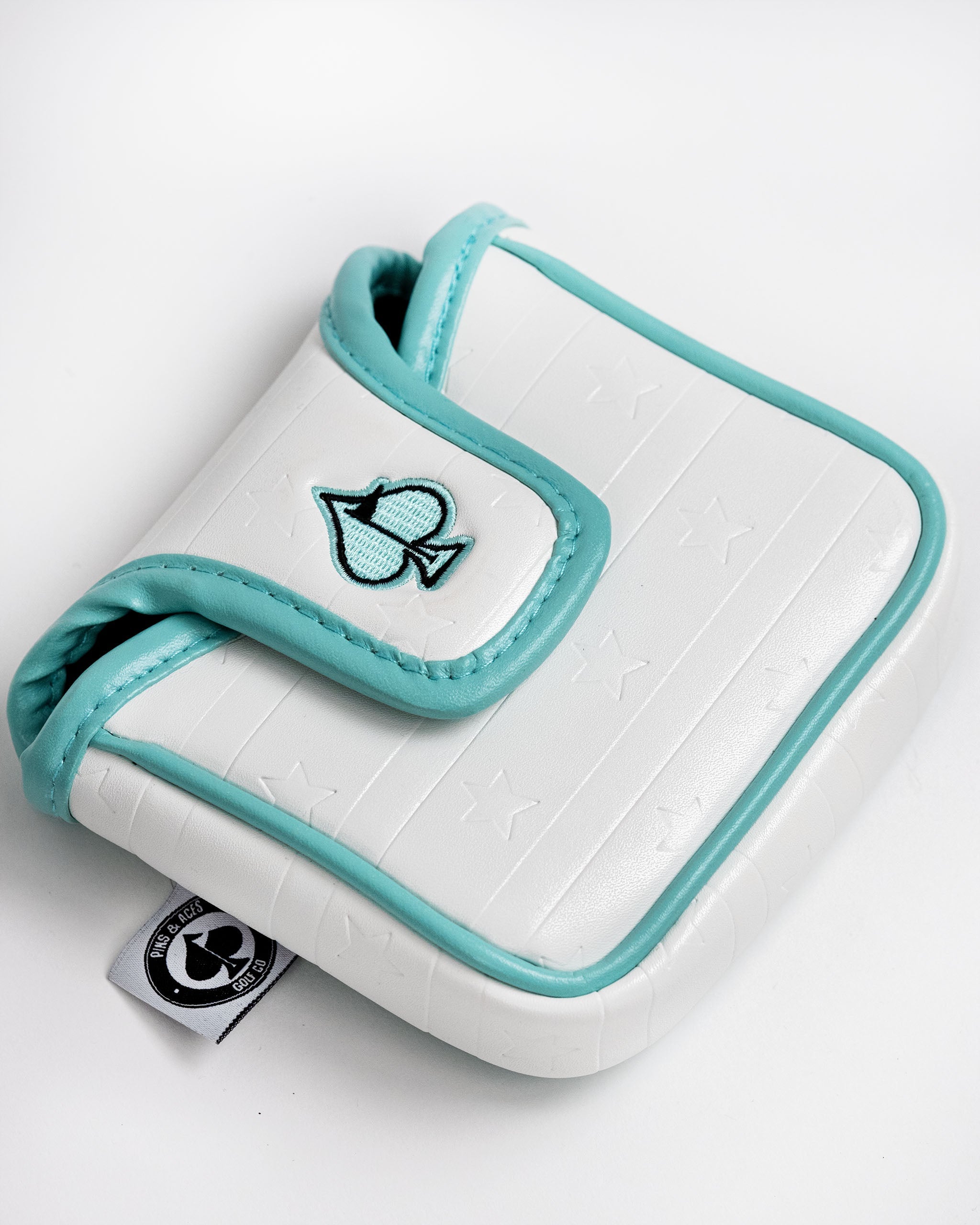 White mallet putter cover with a turquoise trim and star pattern, featuring a playful fish logo on the front.