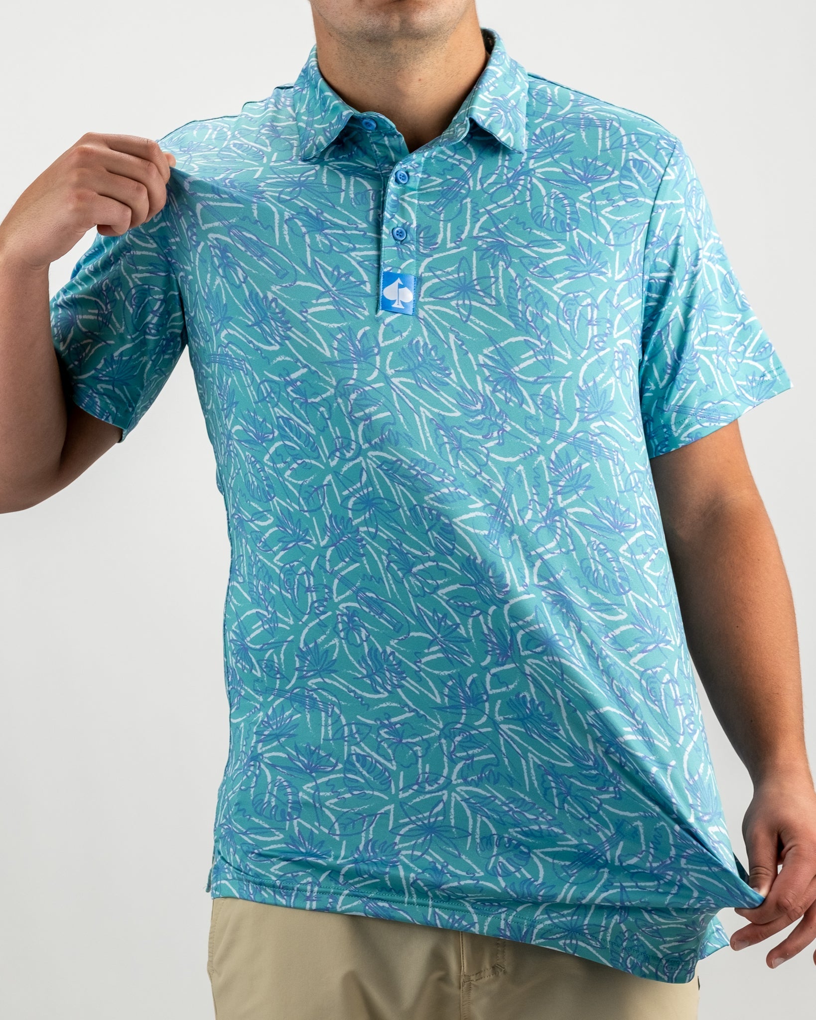 Men's Margaritaville 5 O'Clock Ocean polo shirt featuring a vibrant blue and green tropical leaf pattern.