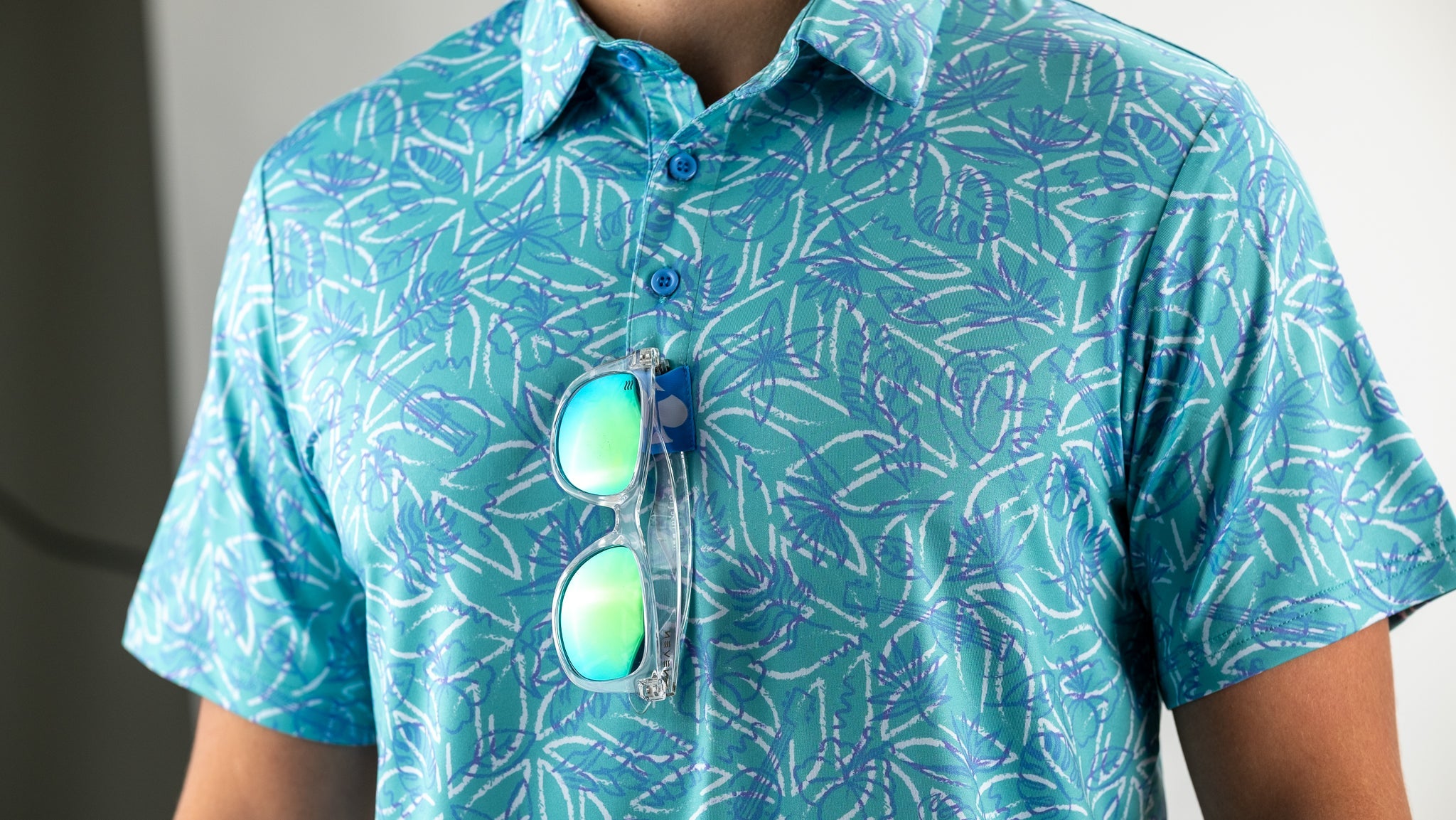 Men's Margaritaville 5 O'Clock Ocean shirt featuring a vibrant leaf pattern, paired with stylish sunglasses for a tropical look.