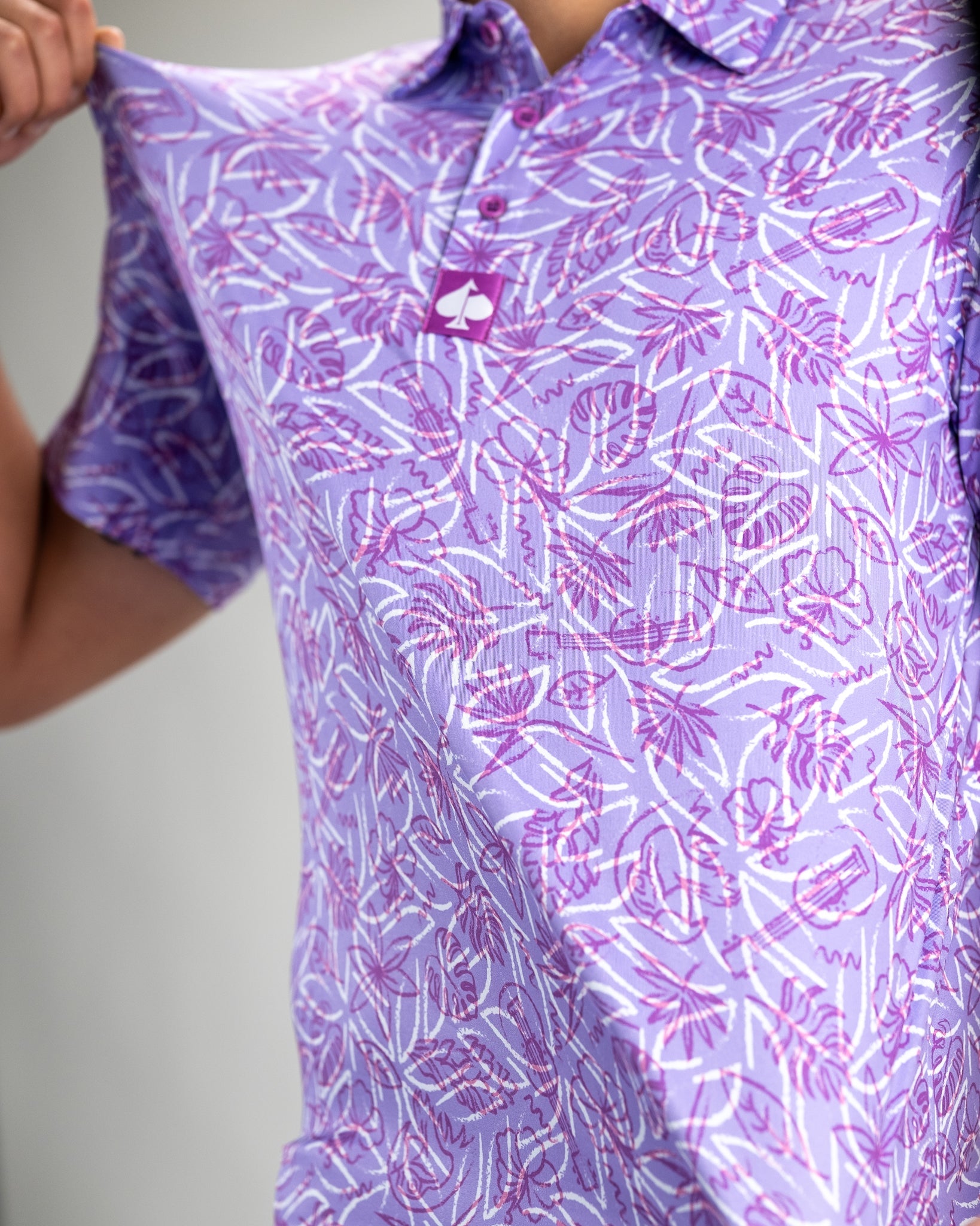 Men's Margaritaville 5 O'Clock Sunset polo shirt featuring a vibrant purple tropical print, perfect for stylish golf outings.
