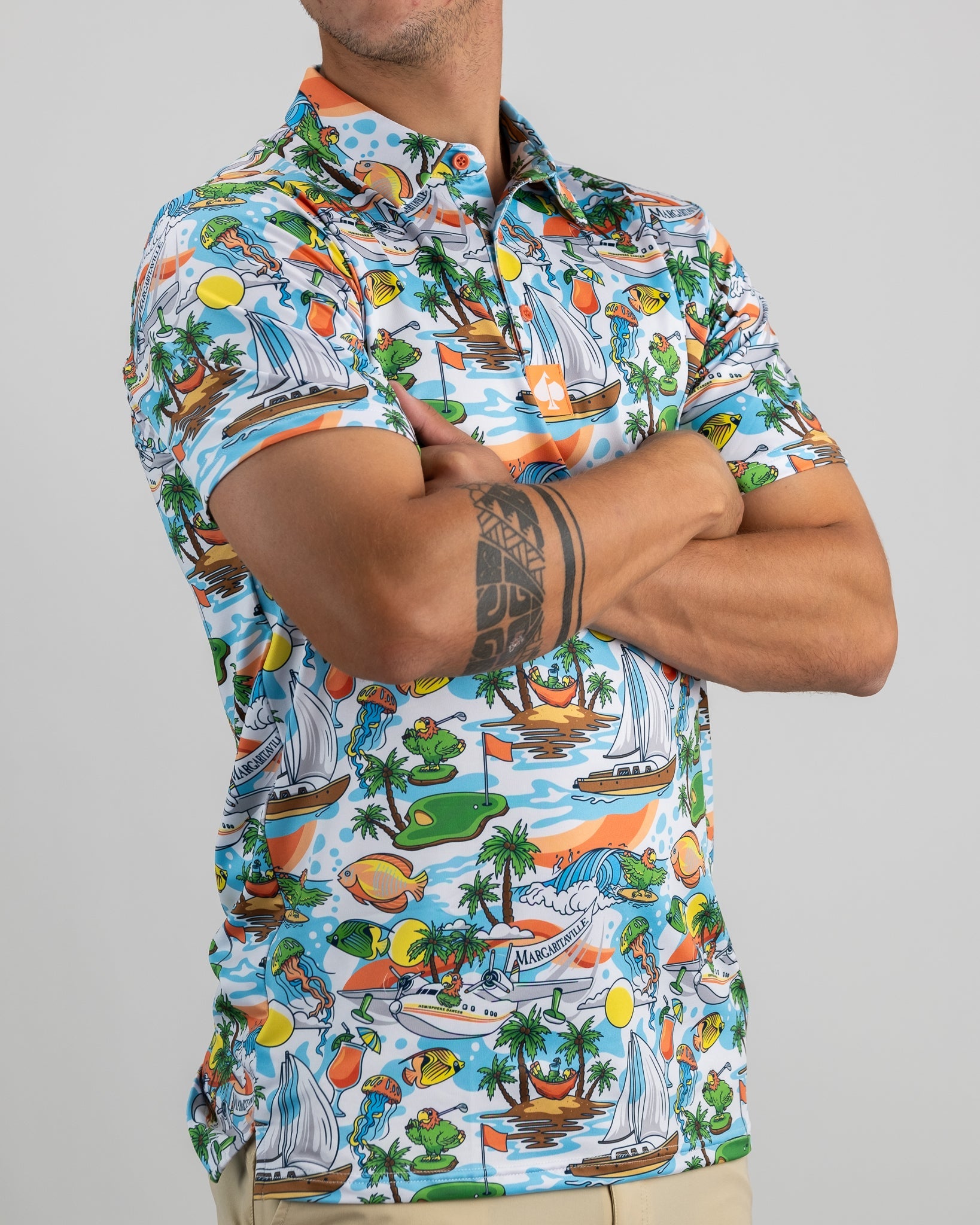 Colorful Margaritaville golf shirt featuring a tropical print with sailboats, palm trees, and vibrant beach elements.