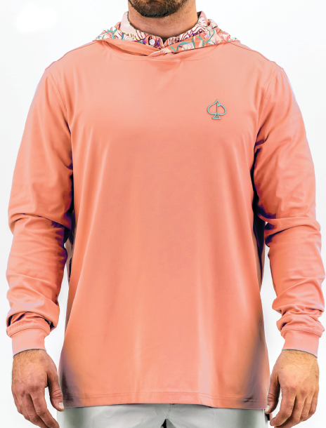 Men's performance golf hoodie in a soft coral shade with a Birds of Paradise patterned hood and logo on the chest.