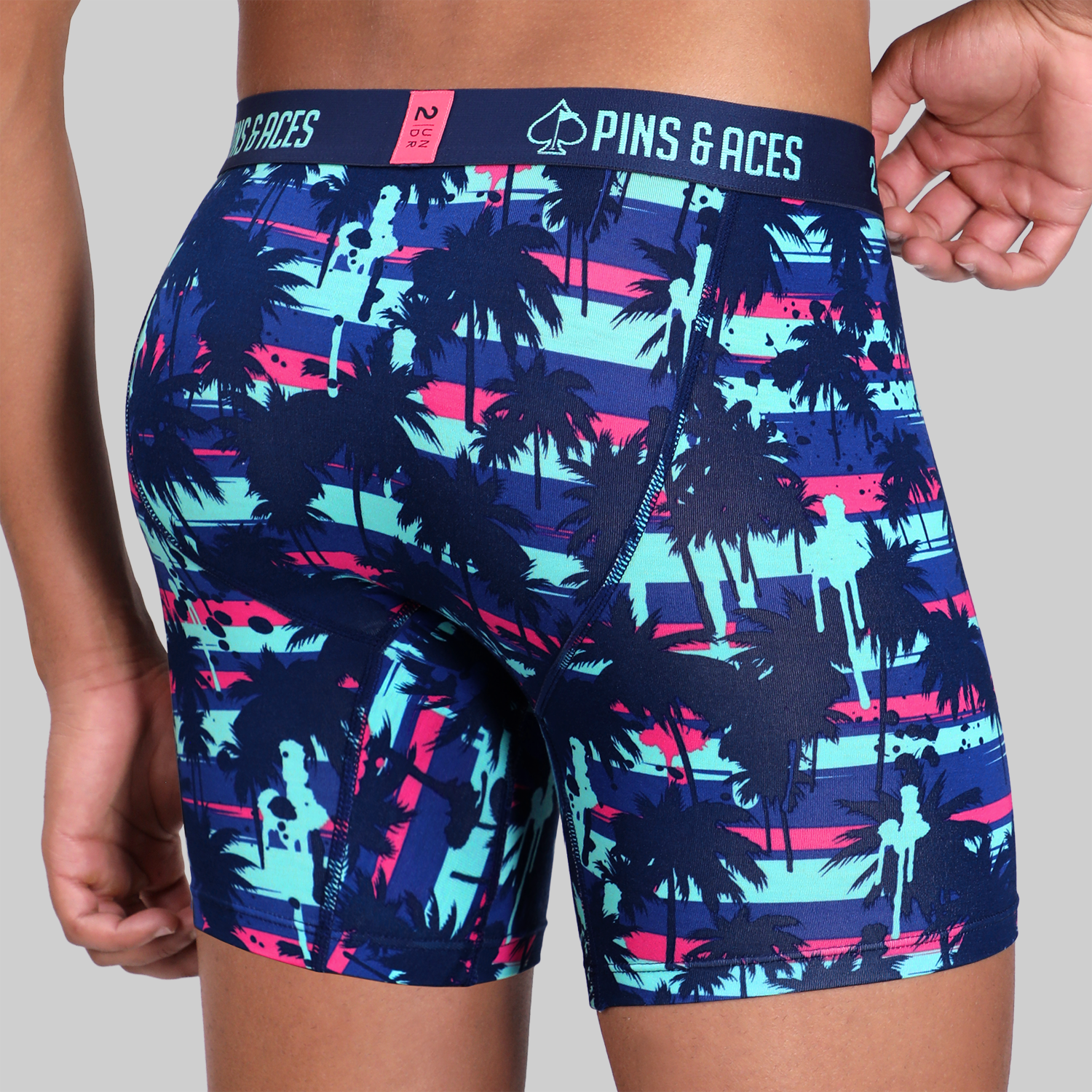 Bold 2UNDR x P&A Swing Shift 6" box briefs featuring a vibrant palm tree design in blue, pink, and purple hues.