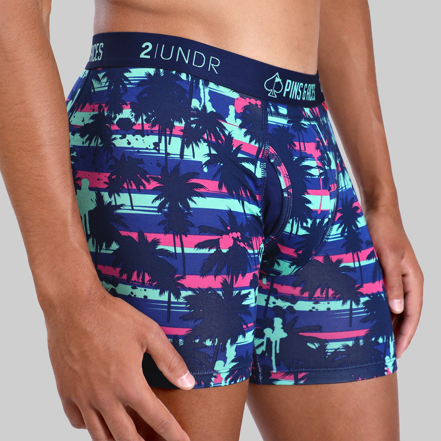 Bold 2UNDR x P&A Swing Shift 6" box briefs featuring a vibrant palm tree design in blue, pink, and green hues.