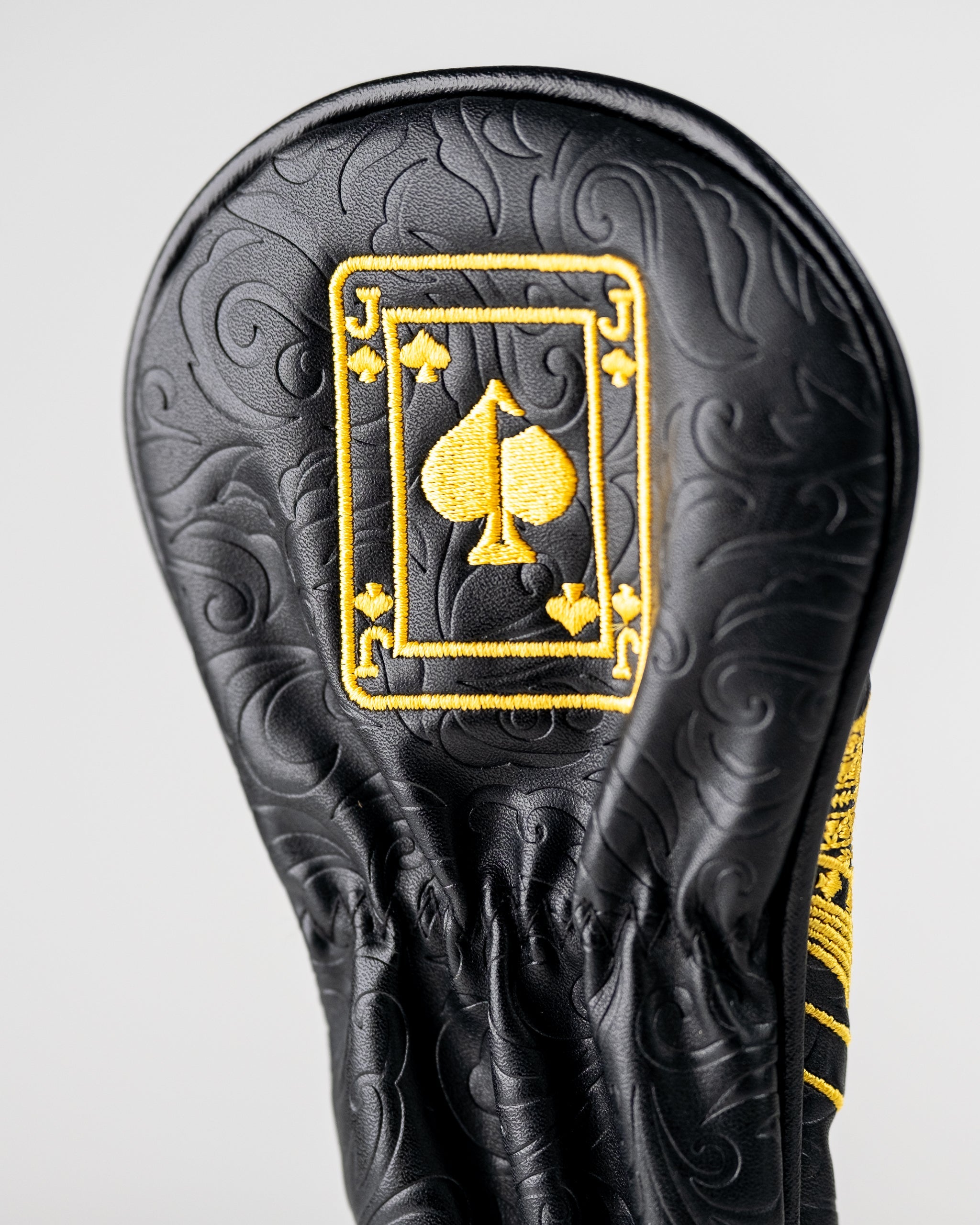 Black and gold hybrid golf club cover featuring an embroidered Jack of Spades design with intricate detailing.