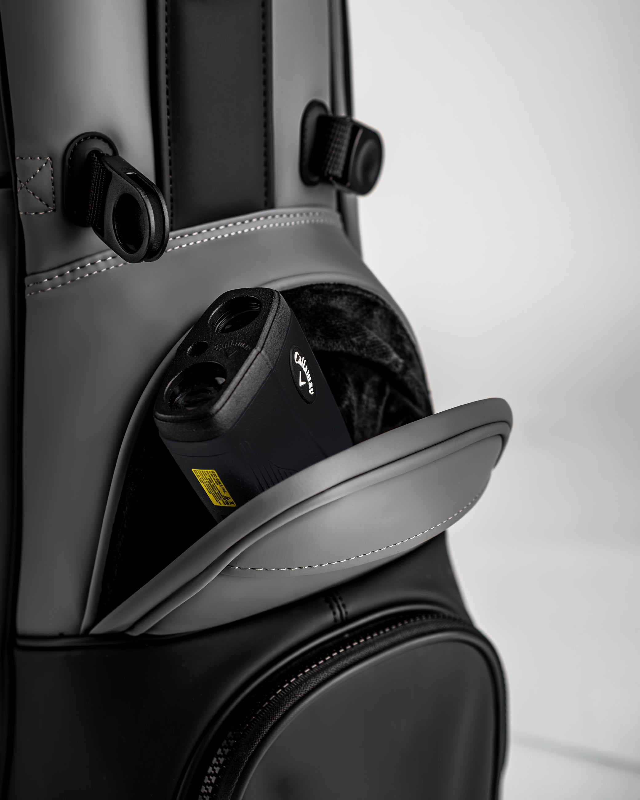 Close-up of the Player Preferred Golf Bag in Flat Ash, featuring a pocket with a golf rangefinder partially visible.