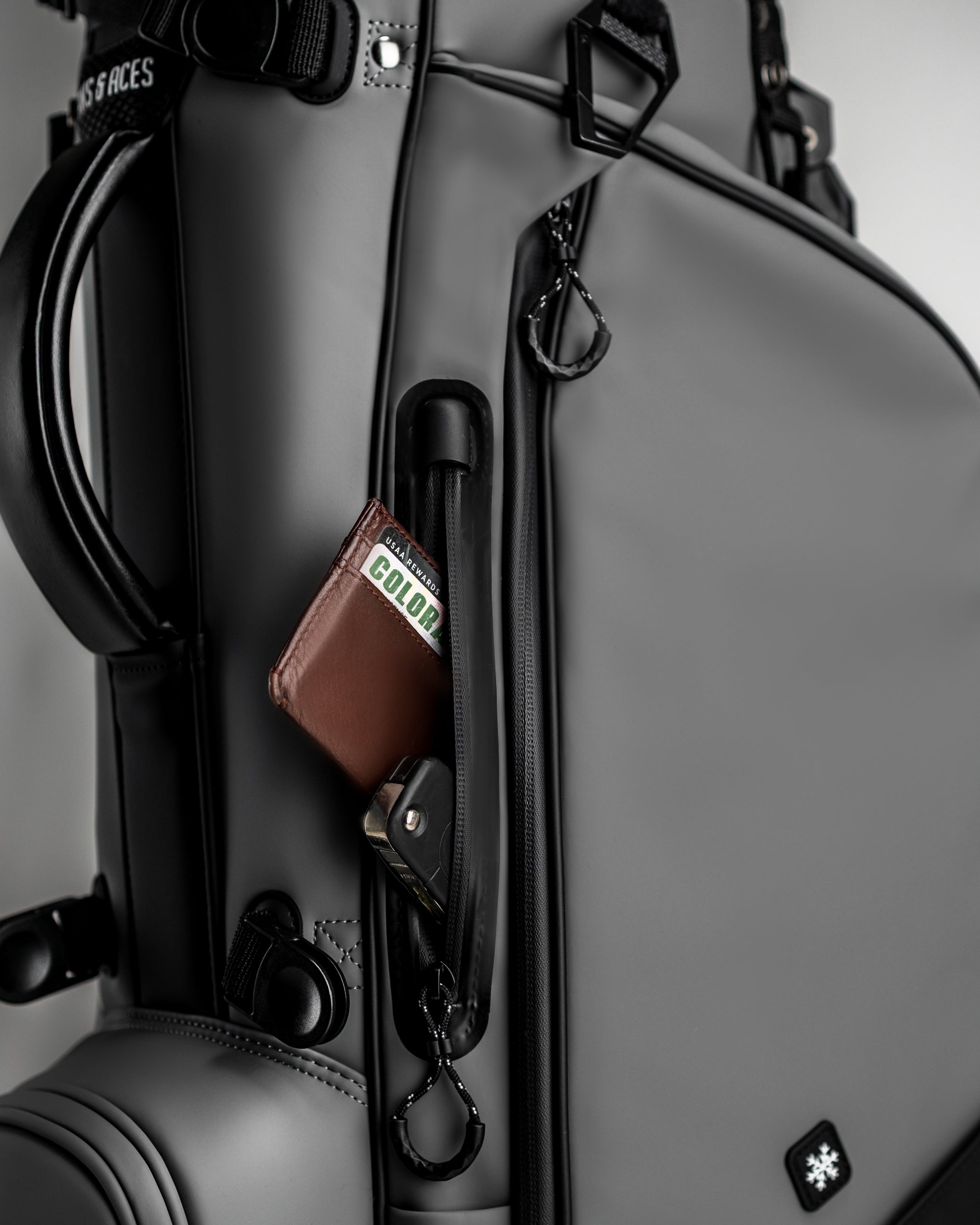 Player Preferred Golf Bag in Flat Ash with a zippered pocket showcasing a wallet and keychain for easy access.