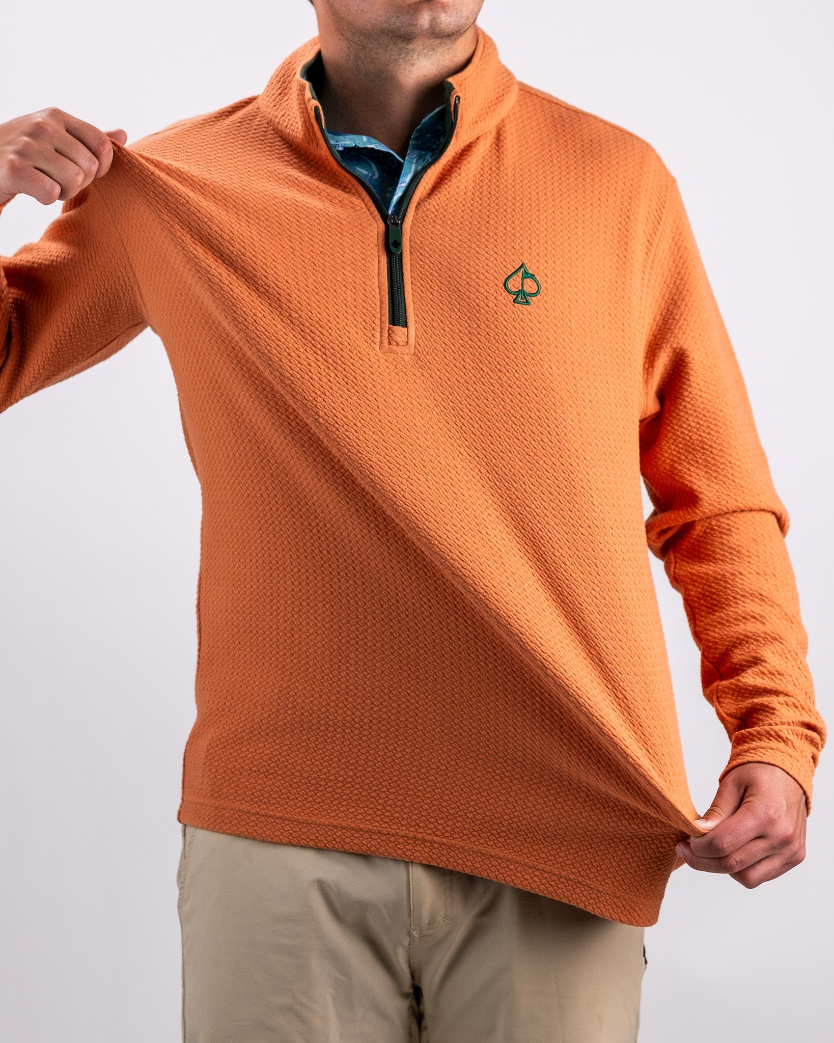 Men's pumpkin-colored waffle knit pullover with a half-zip collar and logo, ideal for stylish golf outings.