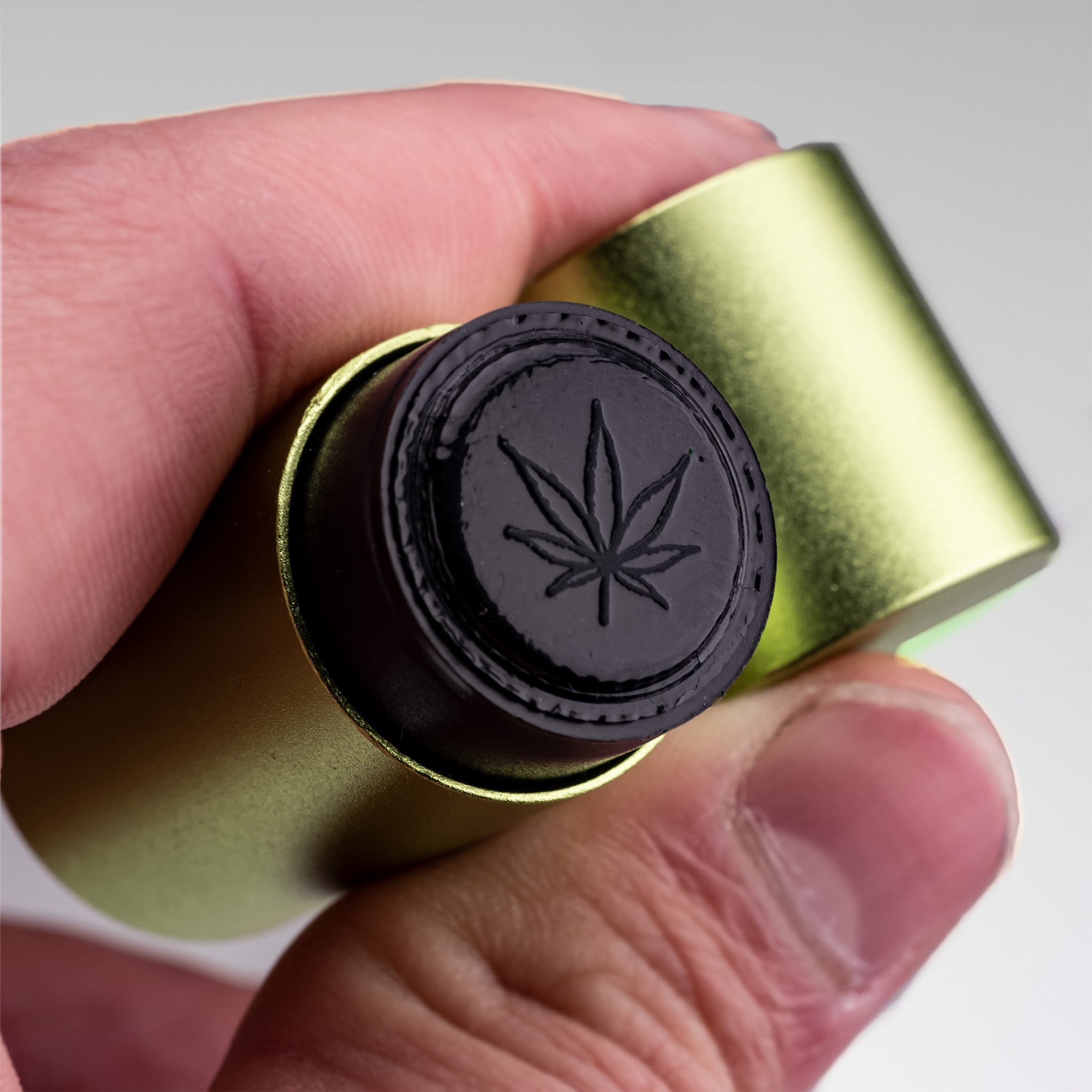 Pot Leaf Ball Stamp held in hand, featuring a detailed cannabis leaf design on a round stamp head.
