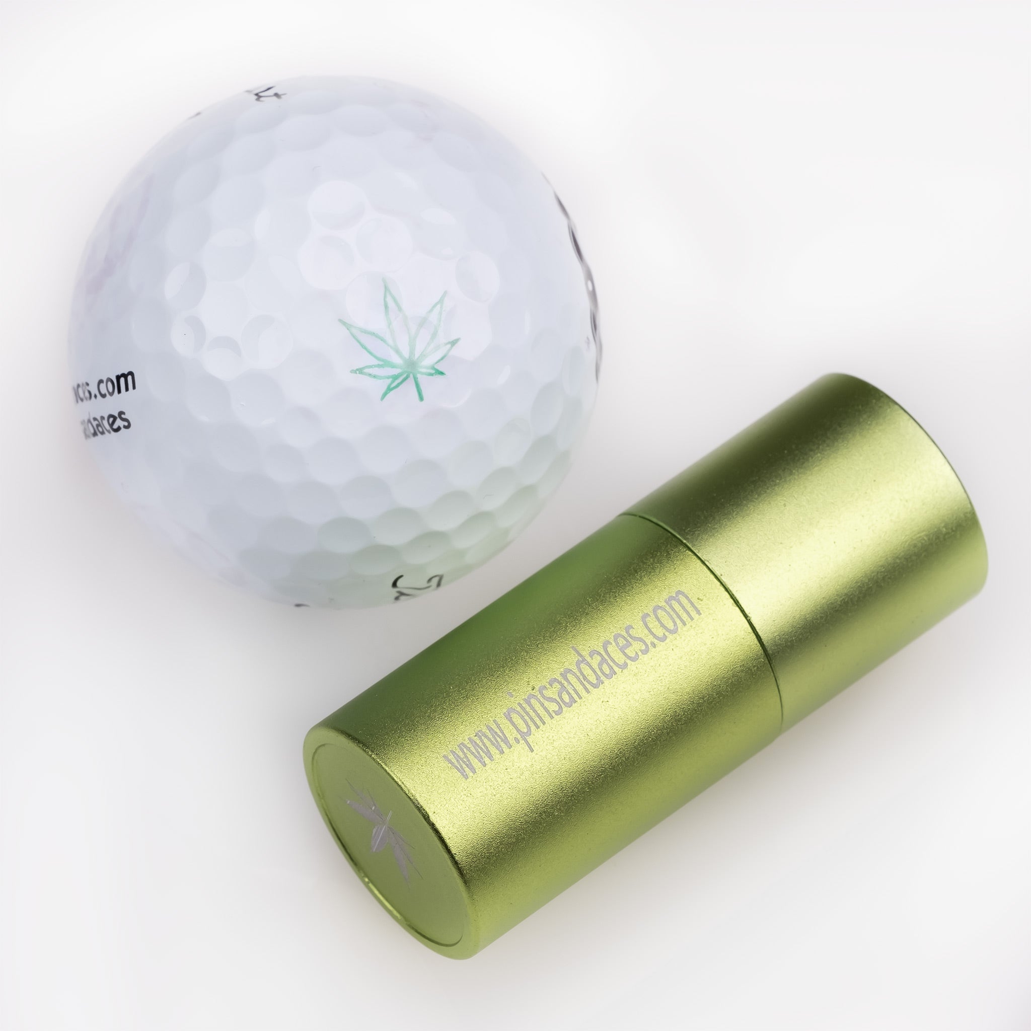 Pot Leaf Ball Stamp next to a white golf ball featuring a green pot leaf design, ideal for personalized golfing style.
