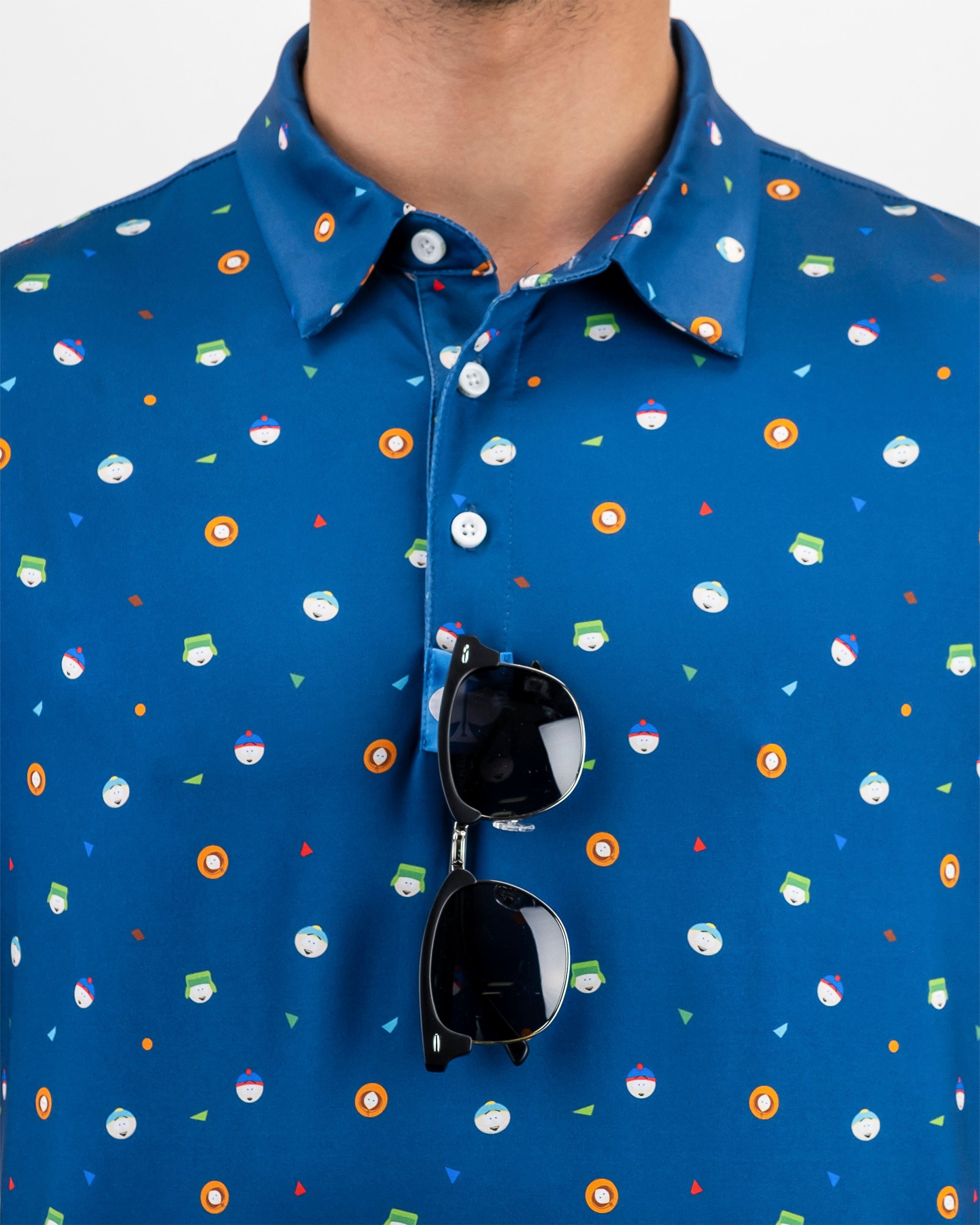 Blue polo shirt featuring a playful pattern of South Park characters and icons, paired with stylish sunglasses.