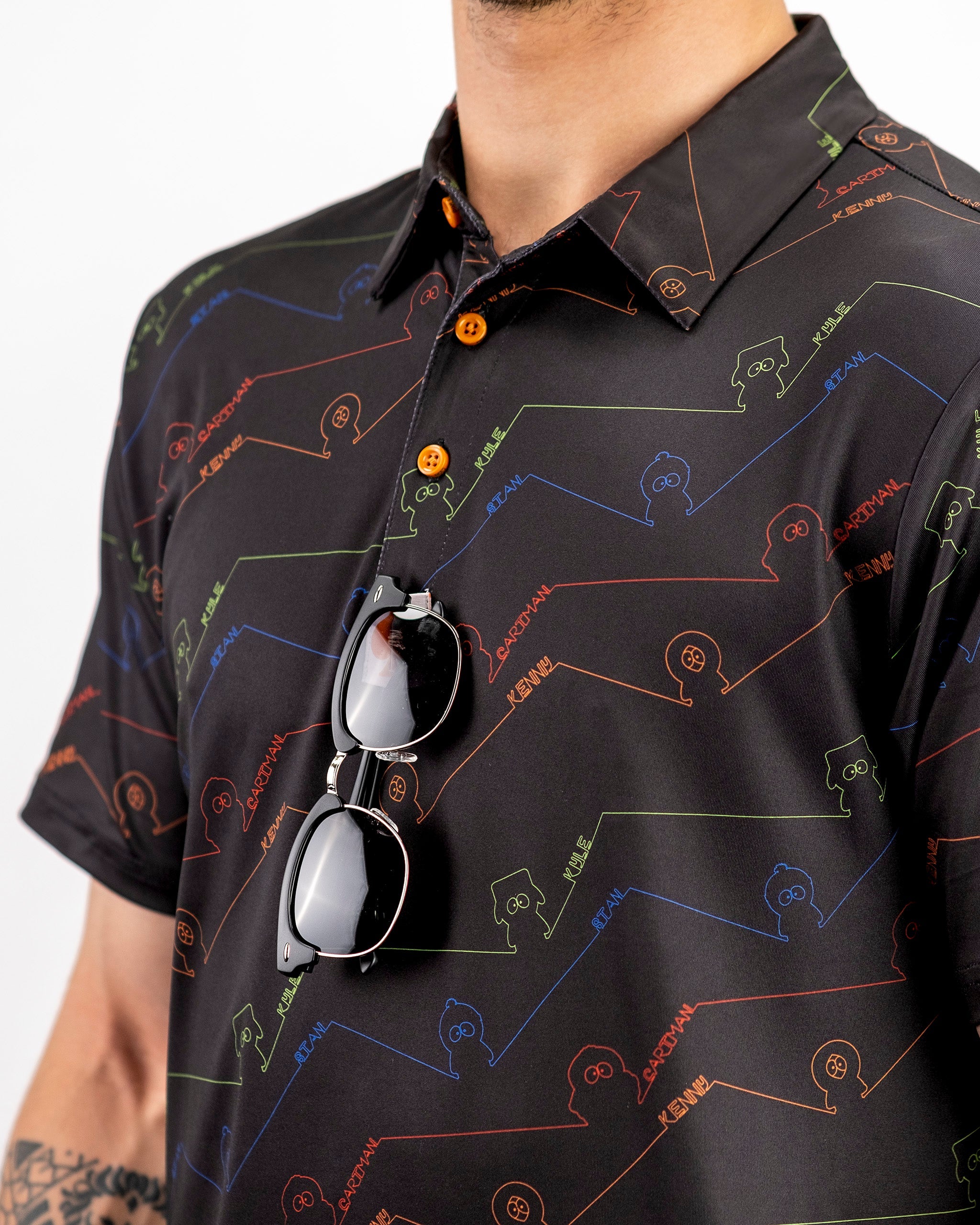 Bold black polo shirt featuring colorful South Park character outlines and playful designs, perfect for standout golf style.