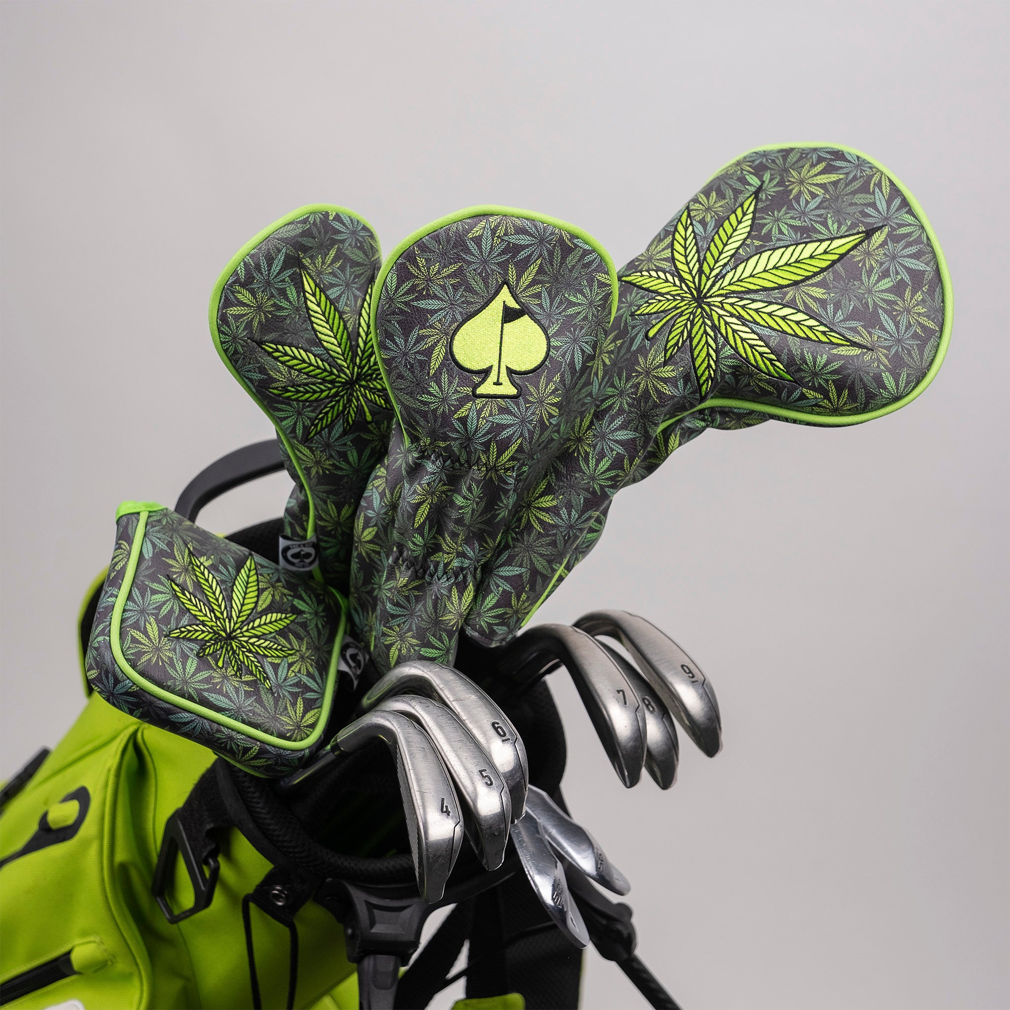 Golf headcovers with bold cannabis leaf and spade designs in green and black, perfect for making a statement on the course.