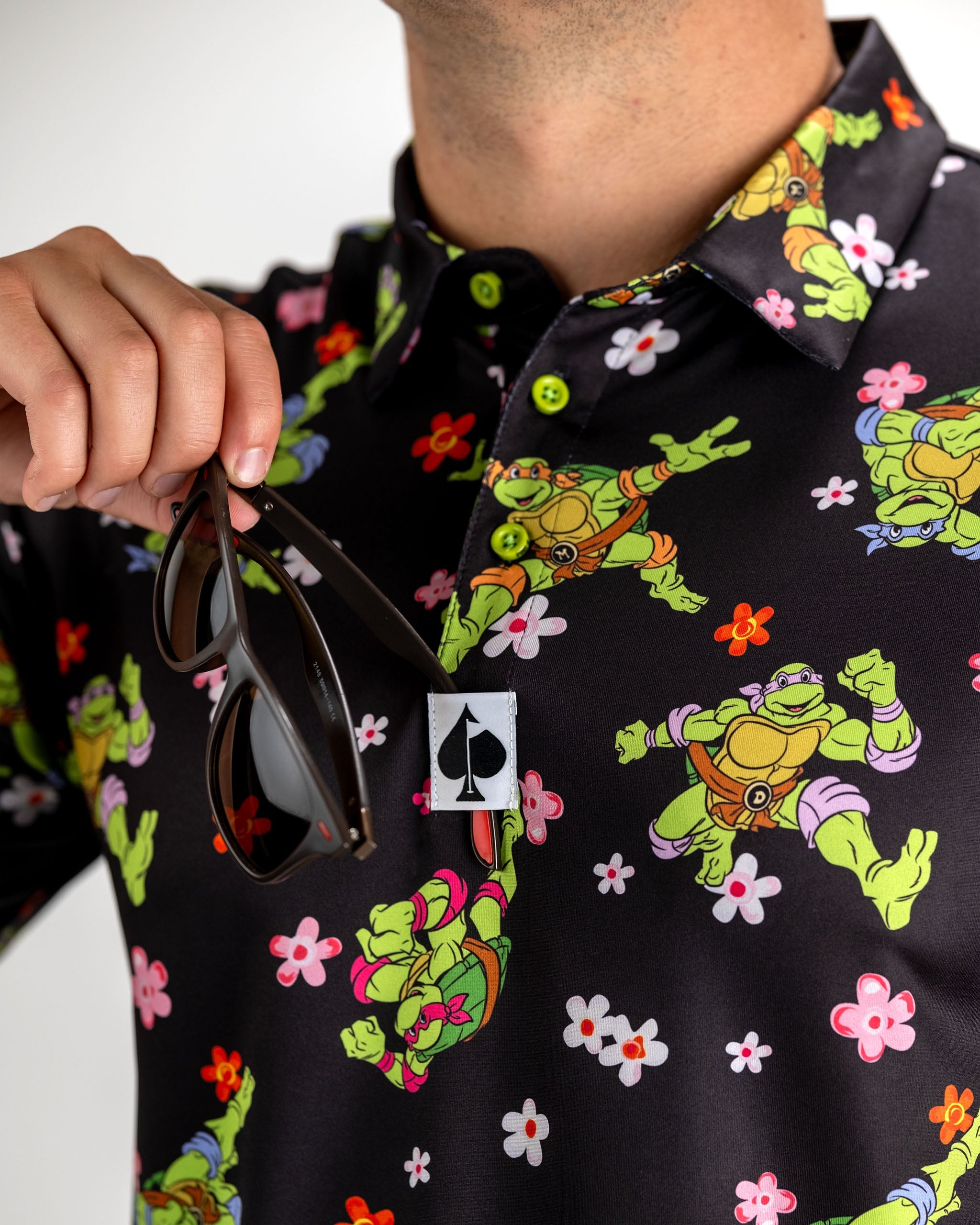 Bold golf polo featuring Teenage Mutant Ninja Turtles in vibrant flower patterns, perfect for stylish golfers.
