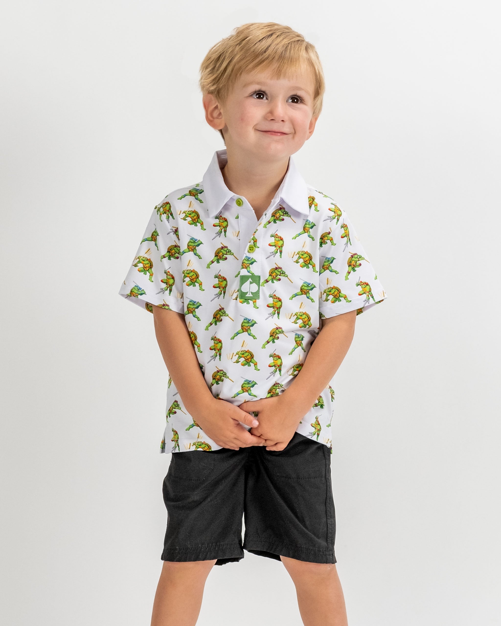 Youth polo shirt featuring a colorful 8-bit Teenage Mutant Ninja Turtles design, perfect for young fans of the franchise.