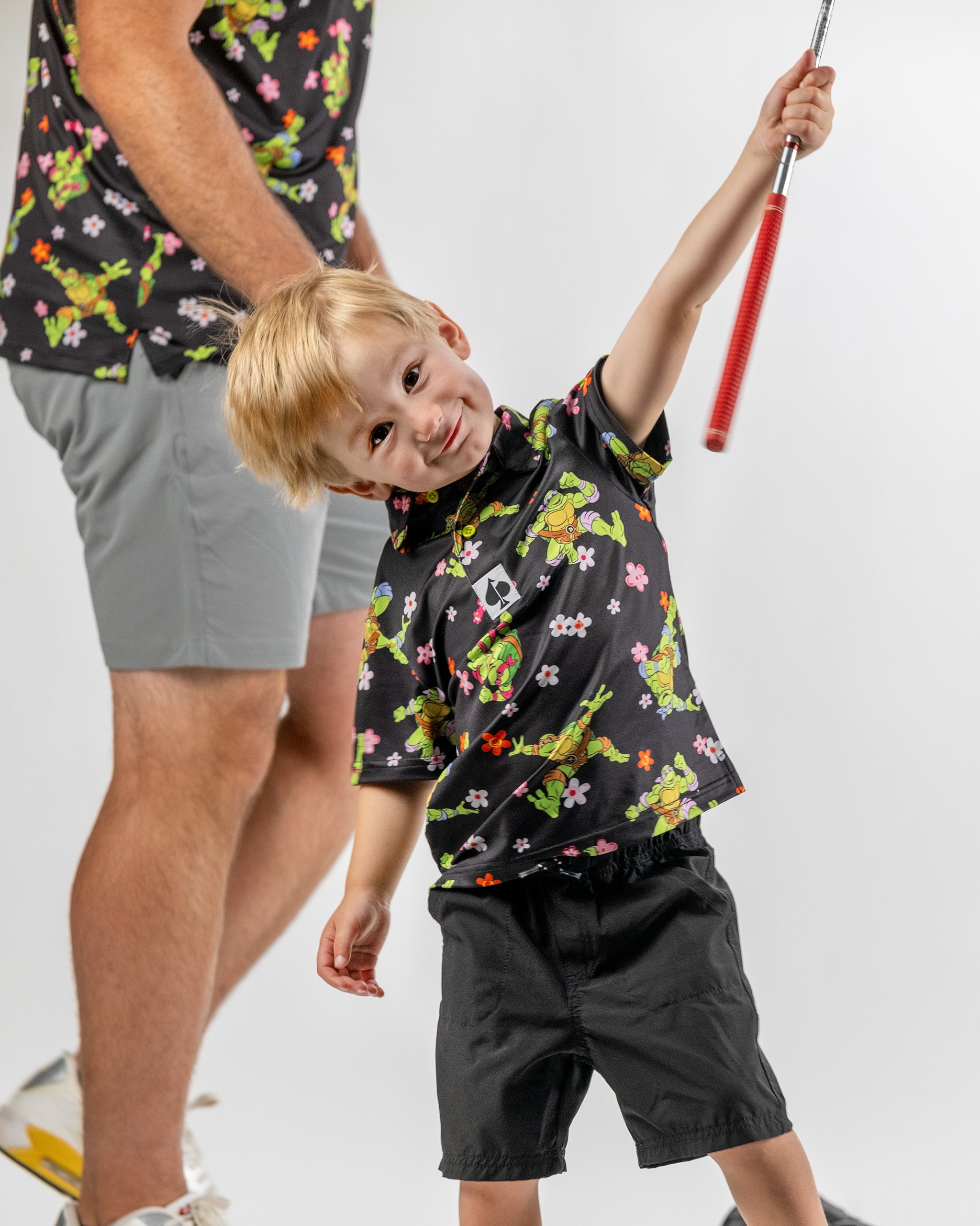 Youth Turtle Flower Power golf shirt featuring vibrant TMNT graphics and floral patterns, perfect for young golfers.