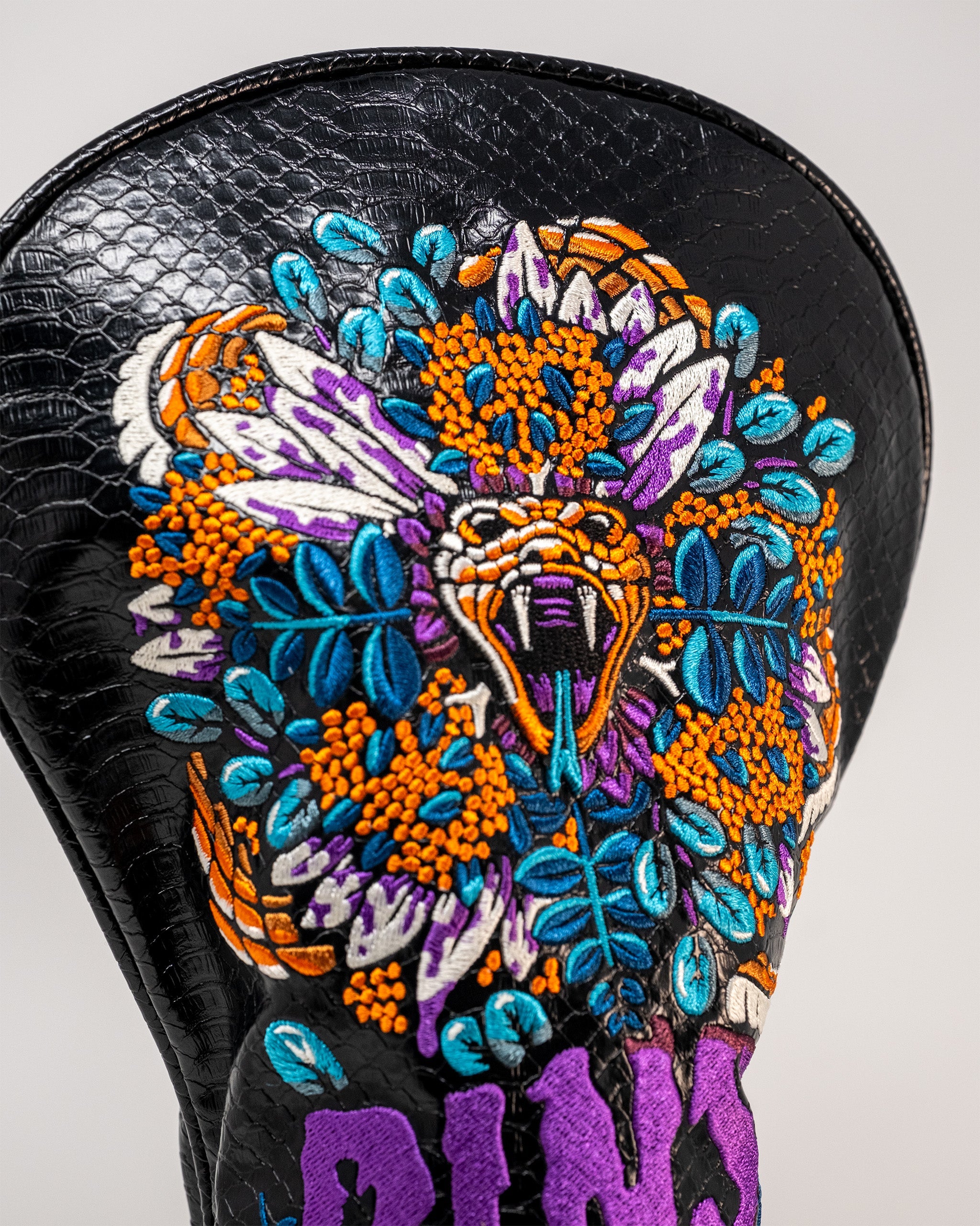 Bold Venom Driver Cover featuring intricate snake and floral embroidery on a textured black background.