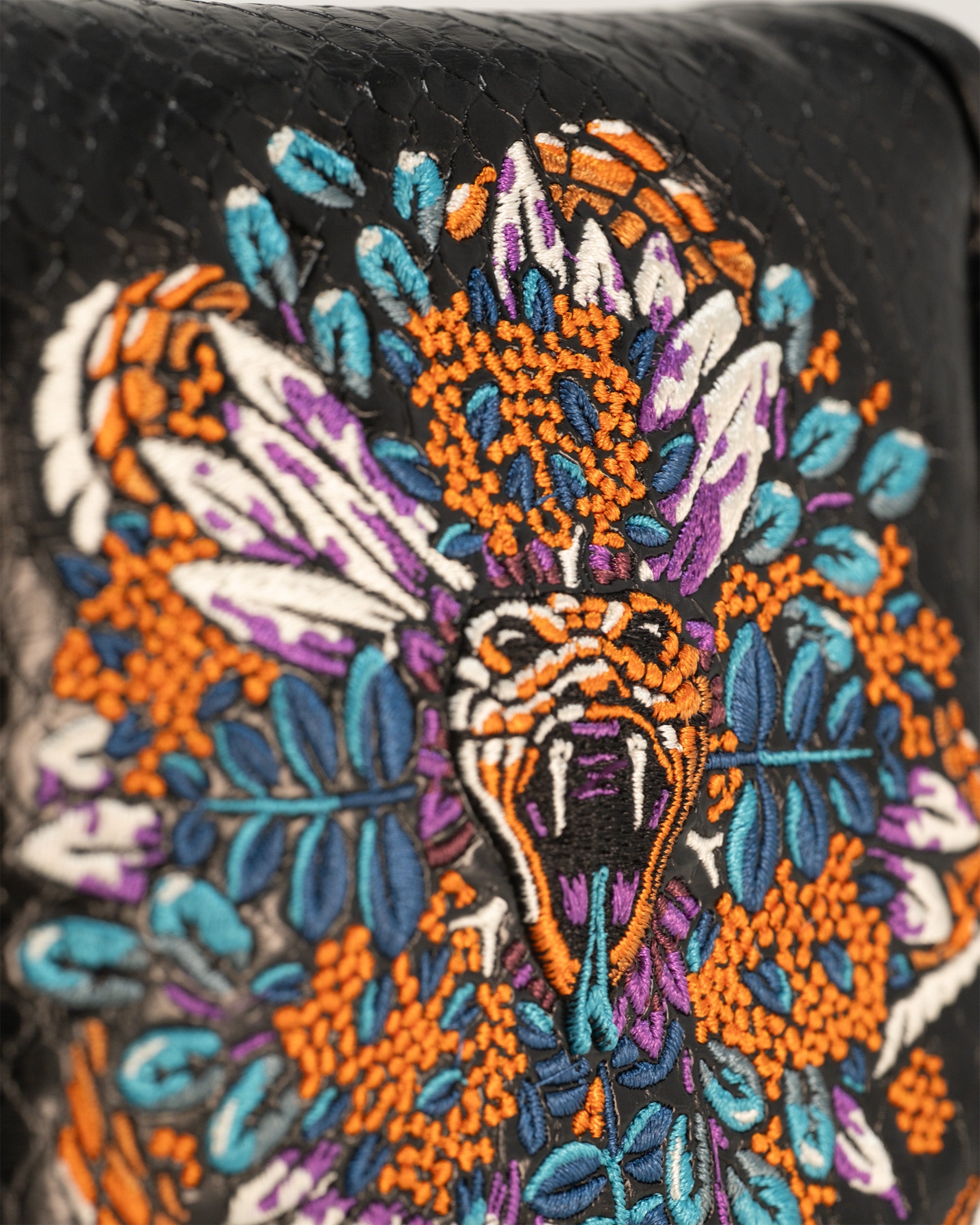 Detailed embroidered venom mallet cover featuring a striking snake design with vibrant colors and floral accents.