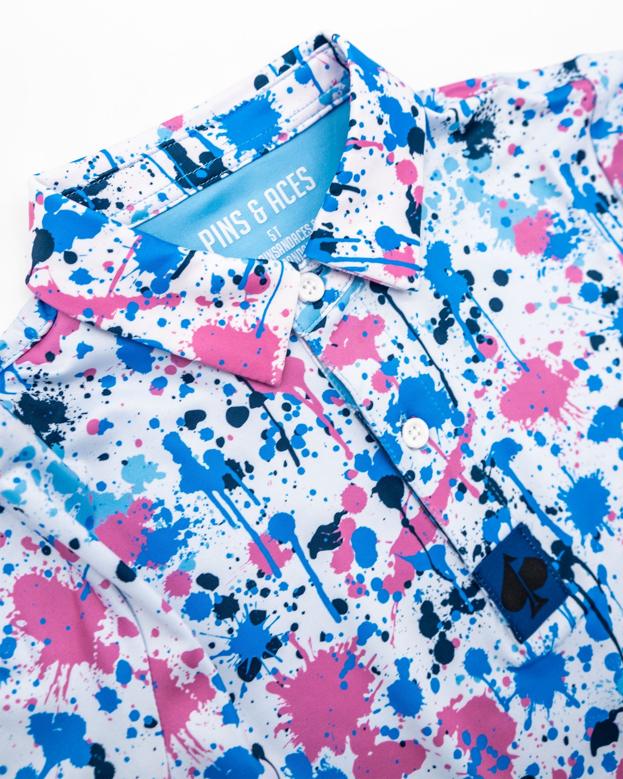 Youth Cotton Candy Drip Polo featuring a vibrant splatter design in pink, blue, and white, perfect for stylish young golfers.