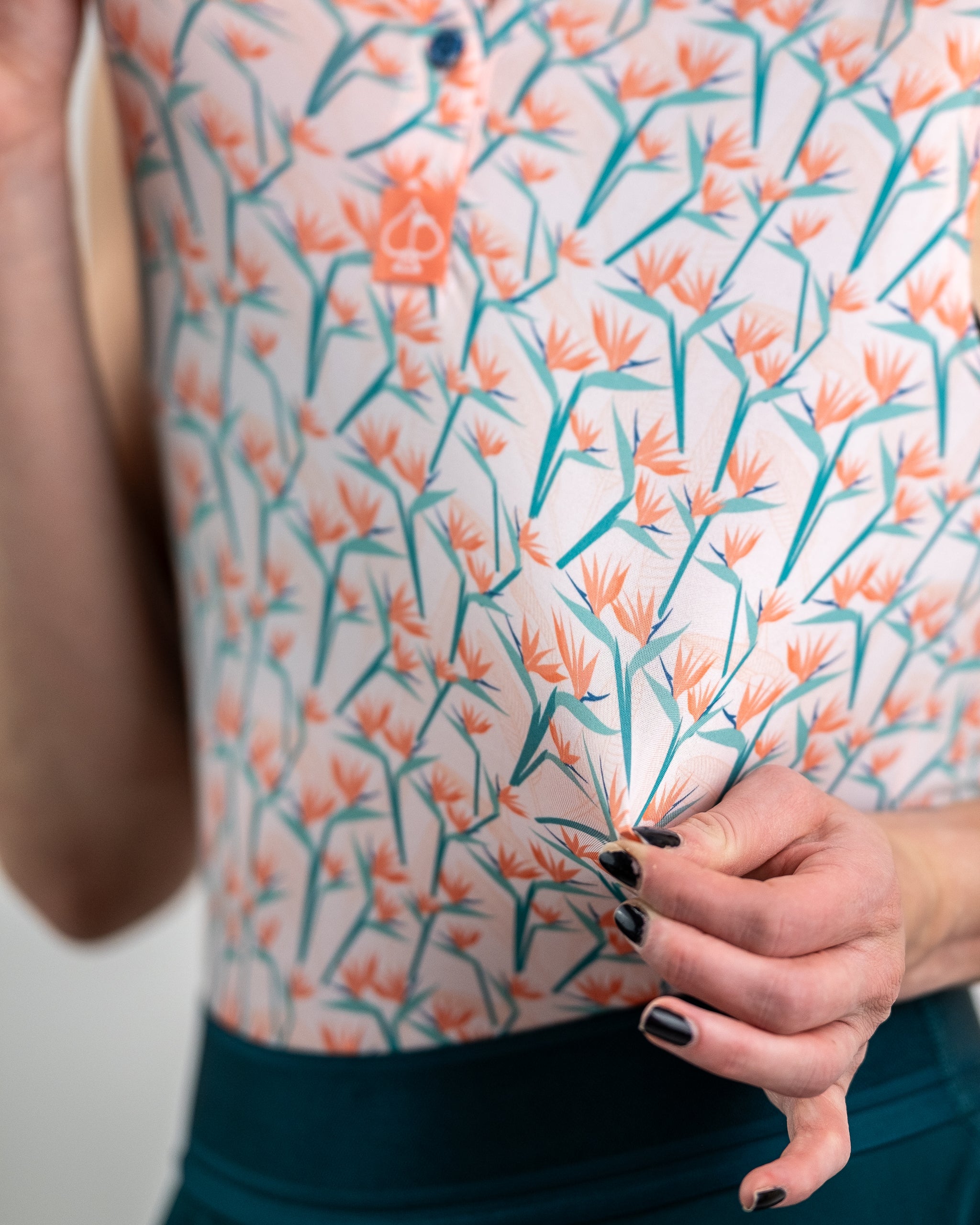 Women's Birds of Paradise dress featuring vibrant floral print and flowing silhouette, displayed on a model outdoors.