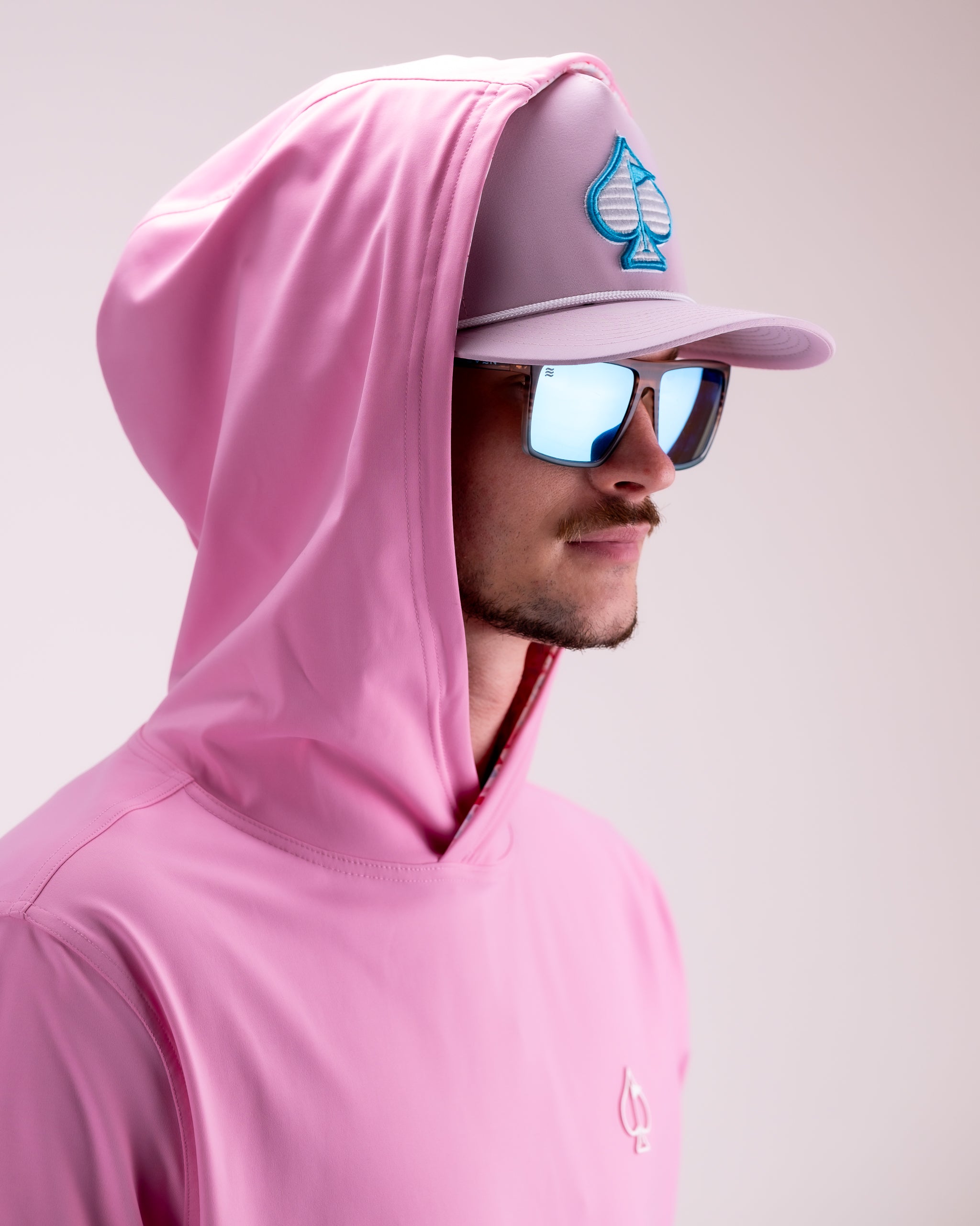 Performance Golf Hoodie in Flamingo Shatter pattern, featuring a modern design and lightweight fabric, displayed on a model in an outdoor setting.