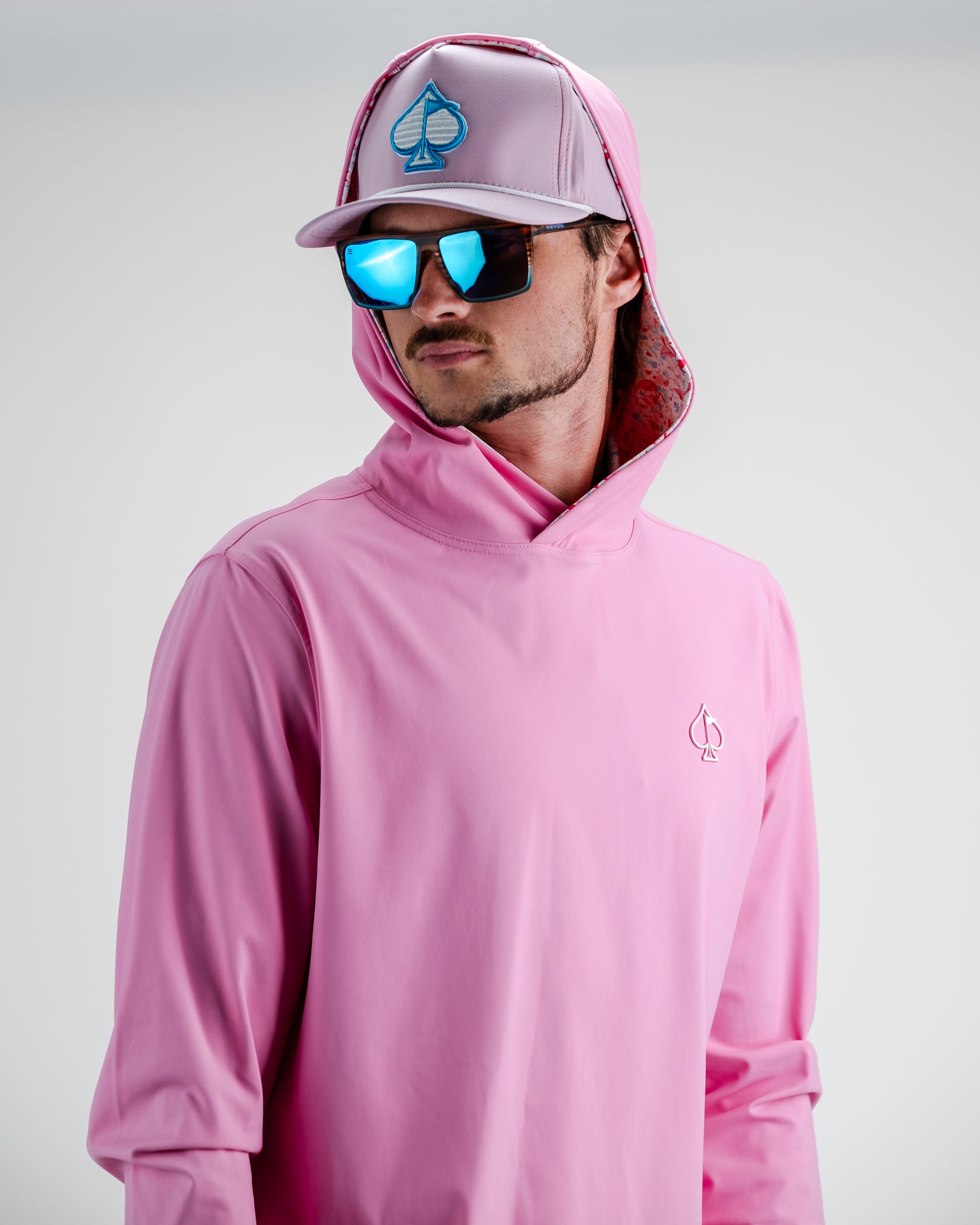 Performance Golf Hoodie in Flamingo Shatter design, features a vibrant pink and black pattern, worn by a model on a golf course.