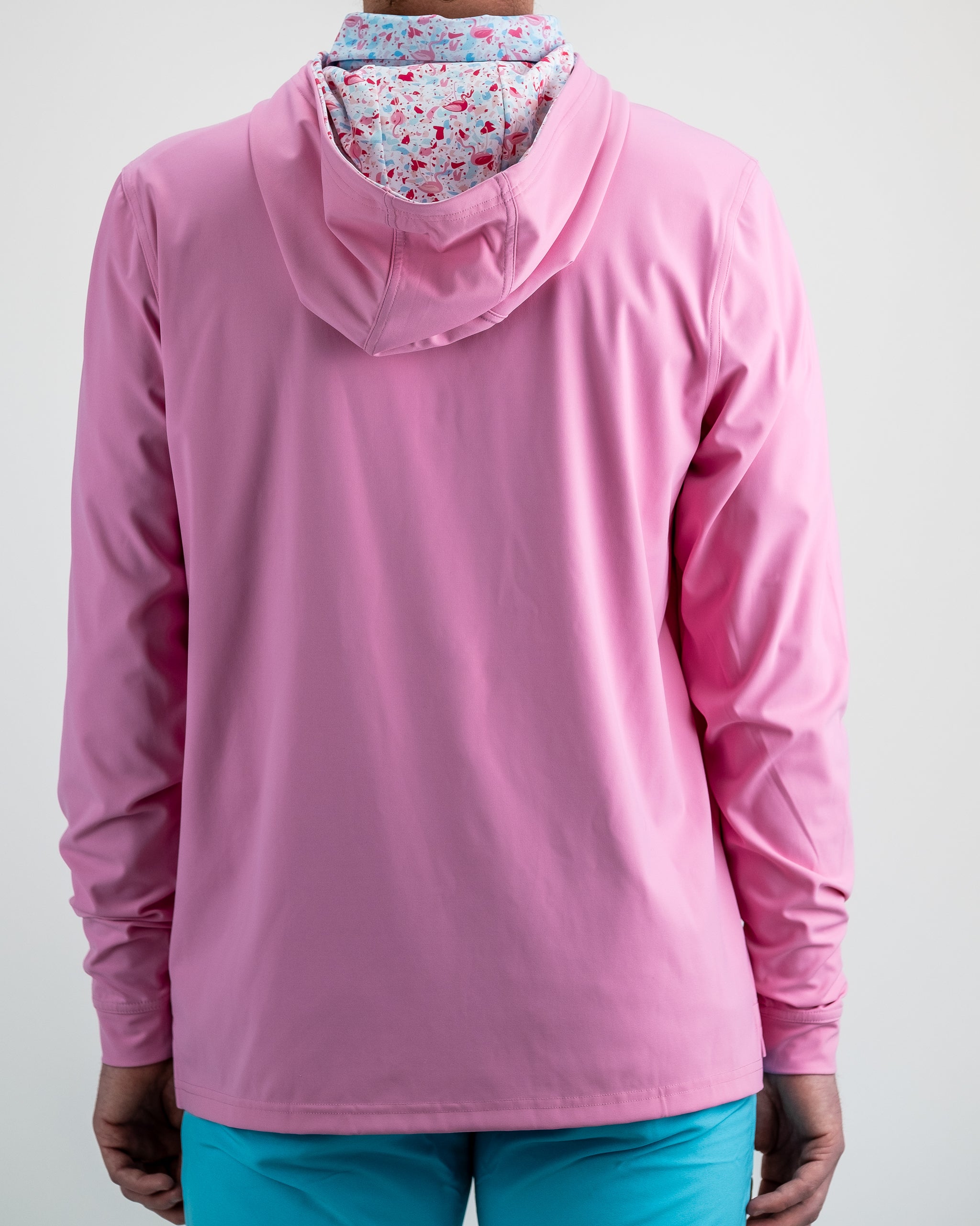 Performance Golf Hoodie in Flamingo Shatter design, featuring a vibrant pink and black color pattern, showcased on a model outdoors.