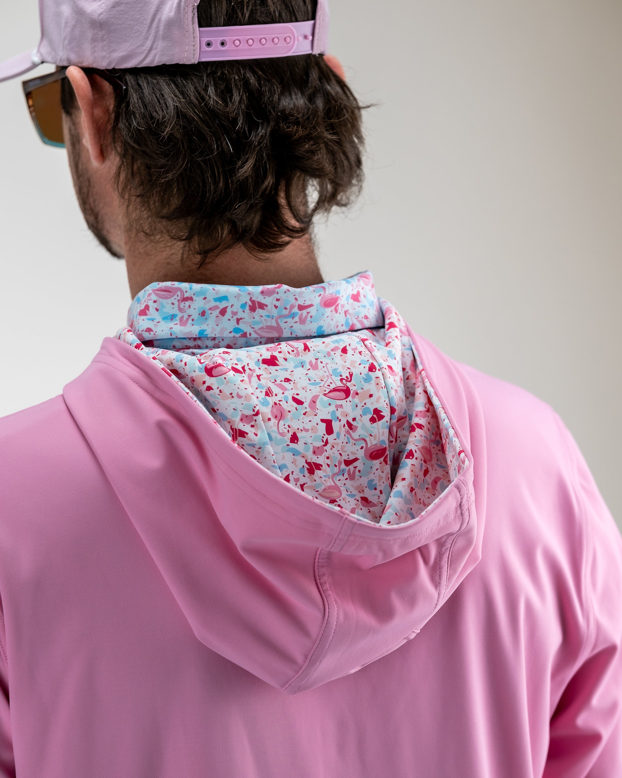 Performance Golf Hoodie in Flamingo Shatter design, featuring a vibrant pink and blue pattern, suitable for active wear.