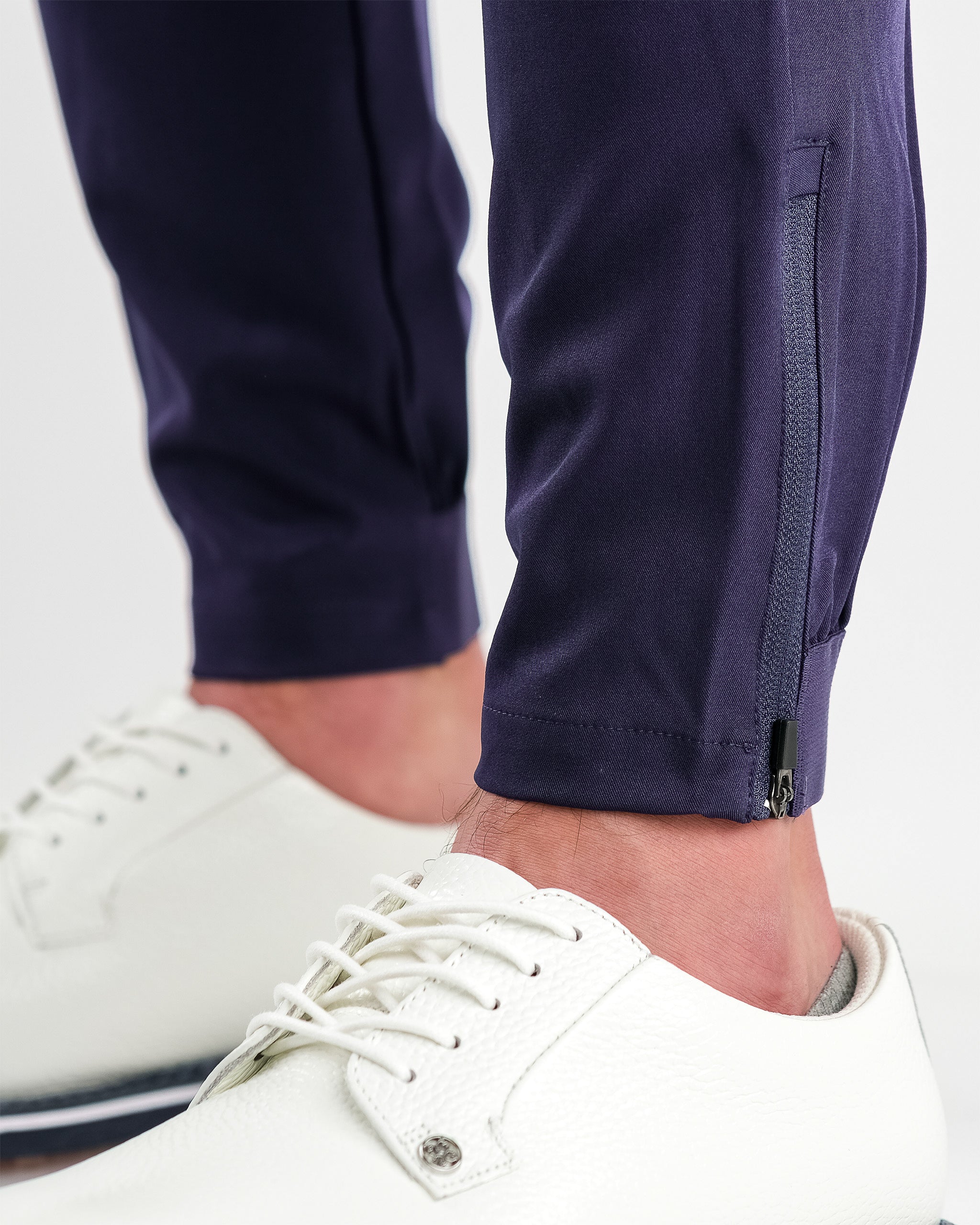 Performance Jogger in Navy, featuring a slim fit and elastic waistband, displayed on a model outdoors.