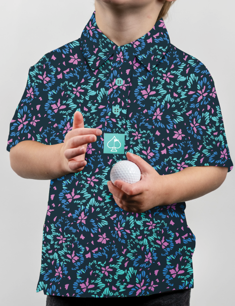 Youth wearing a vibrant fluorescent floral golf shirt, holding a golf ball, showcasing a playful and stylish design.