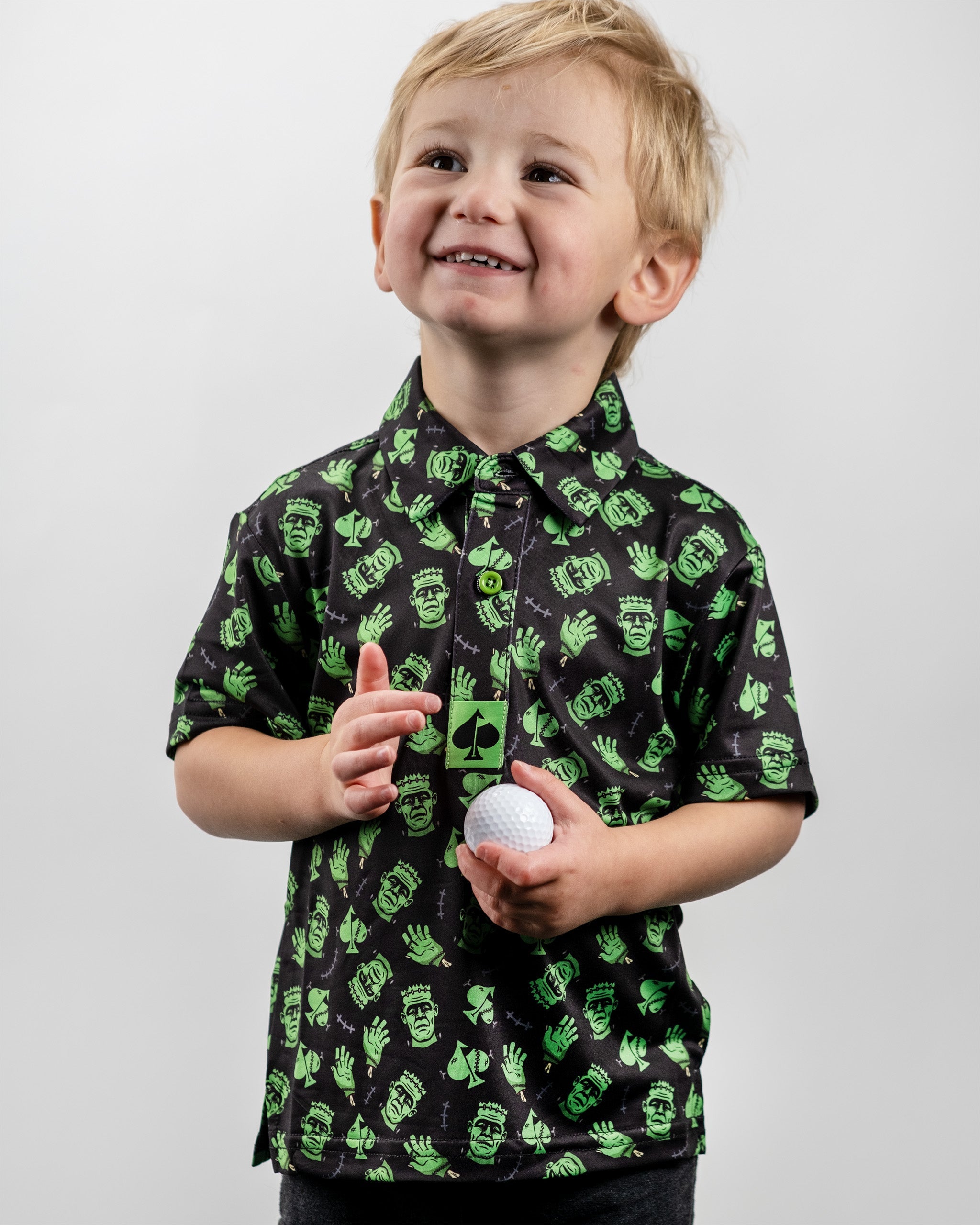 Youth Frankenstein Polo featuring a playful green and black design with cartoon Frankenstein motifs, perfect for young golfers.