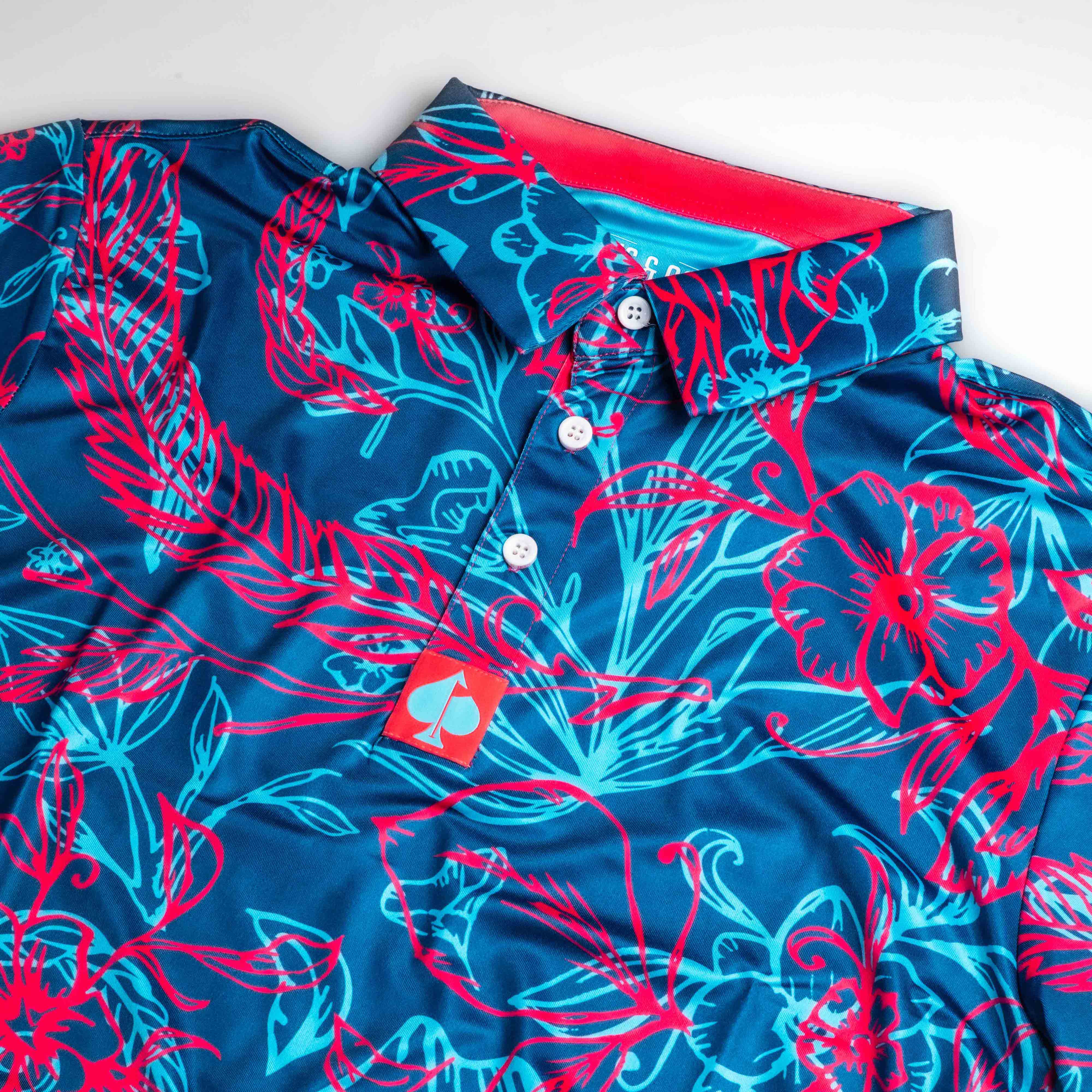 Bold blue and pink floral polo shirt with a collar, showcasing a vibrant tropical design perfect for golfers.