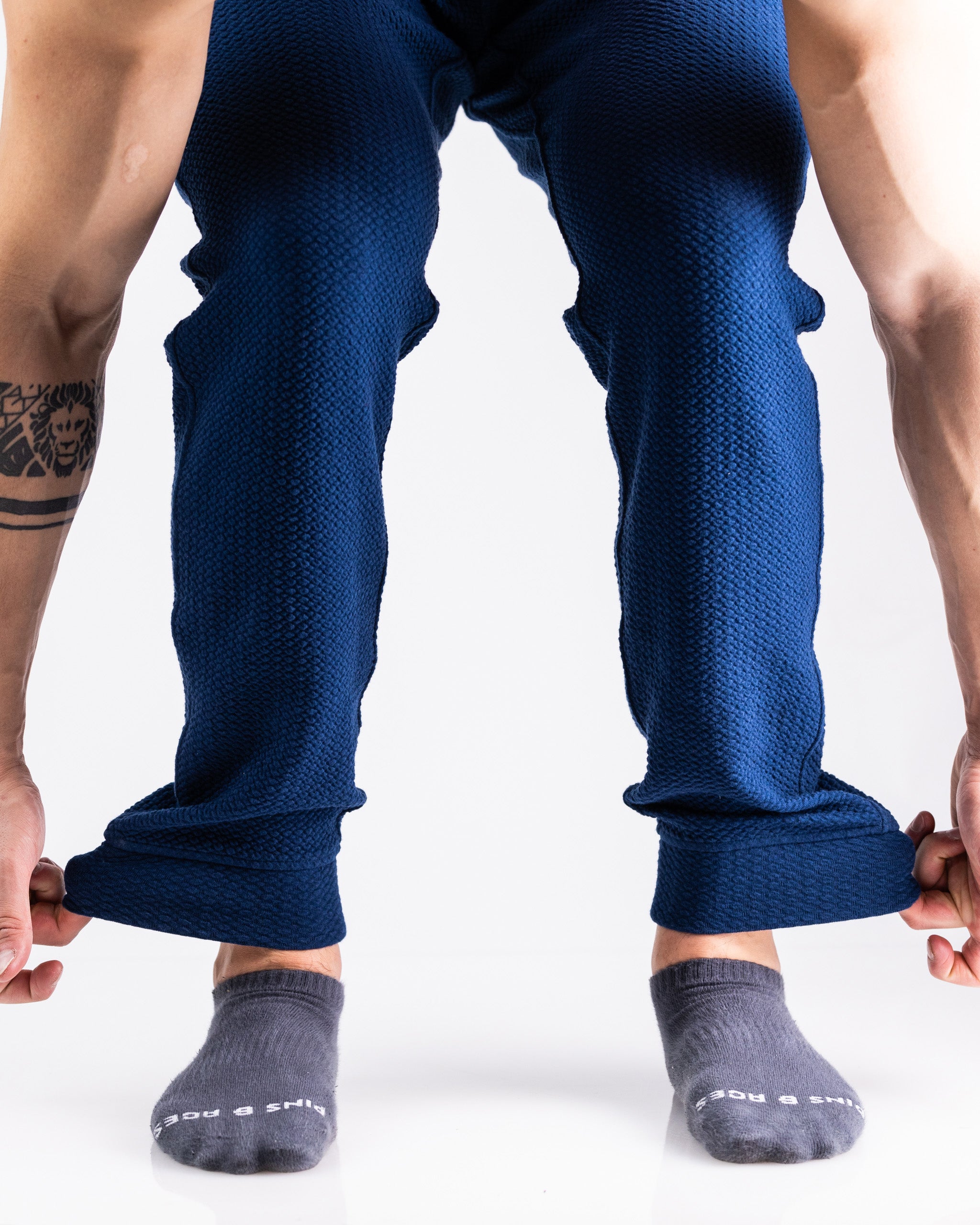 Bold blue textured golf pants with rolled cuffs, styled for standout golf apparel.