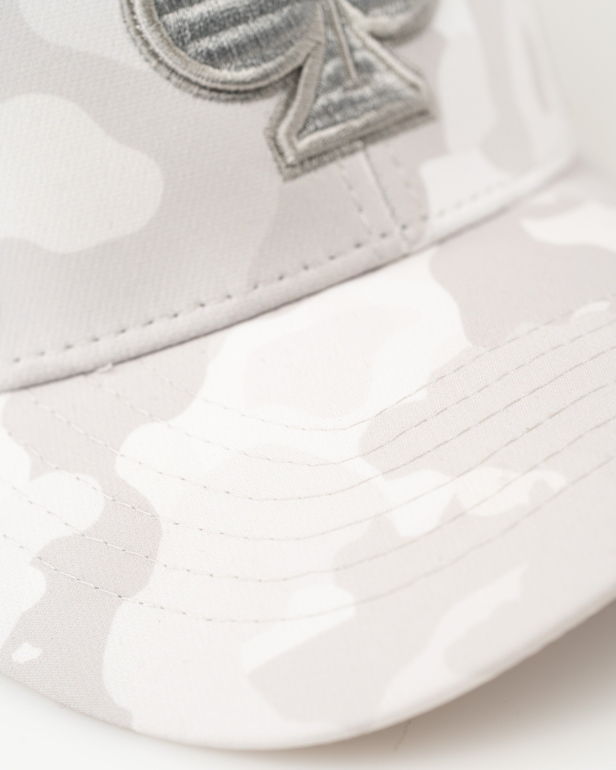 Trucker hat in Arctic Camo featuring a subtle gray camouflage pattern and a prominent logo on the front.