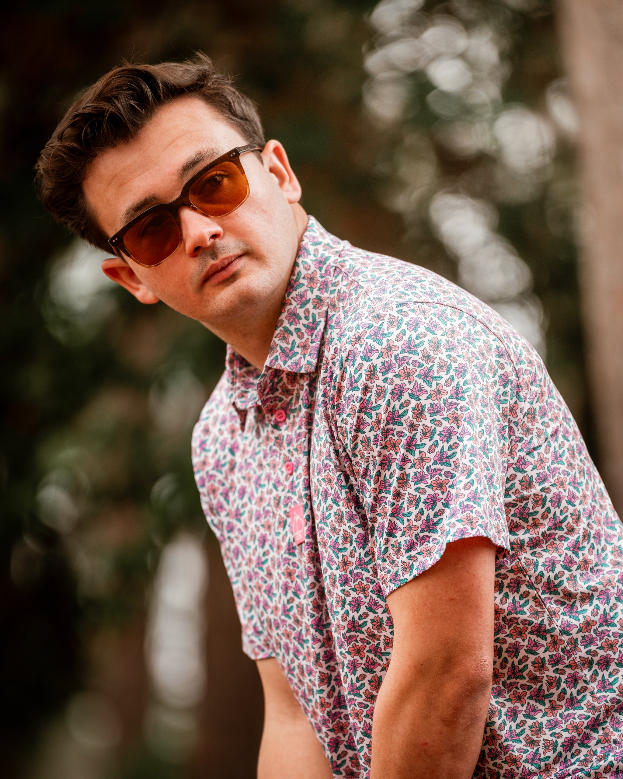 Light Azalea shirt featuring a vibrant floral pattern, worn by a man in sunglasses, set against a natural background.