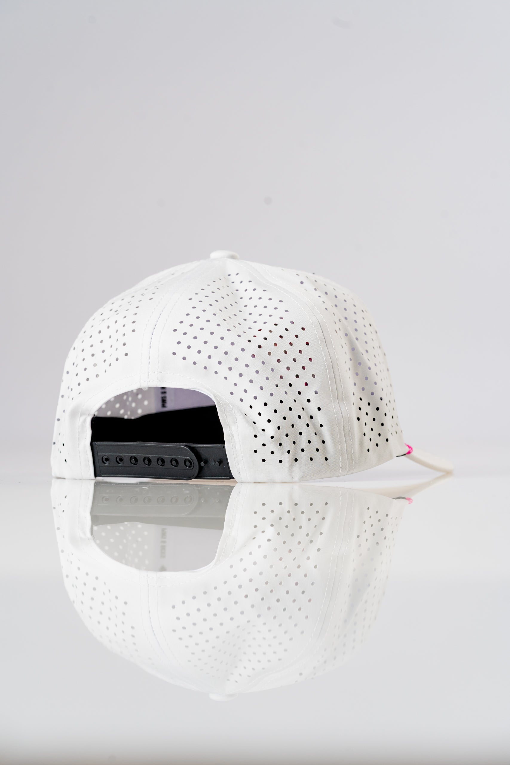 Perforated white rope hat with adjustable strap, featuring a sleek design for stylish golfers. Ideal for warm weather.