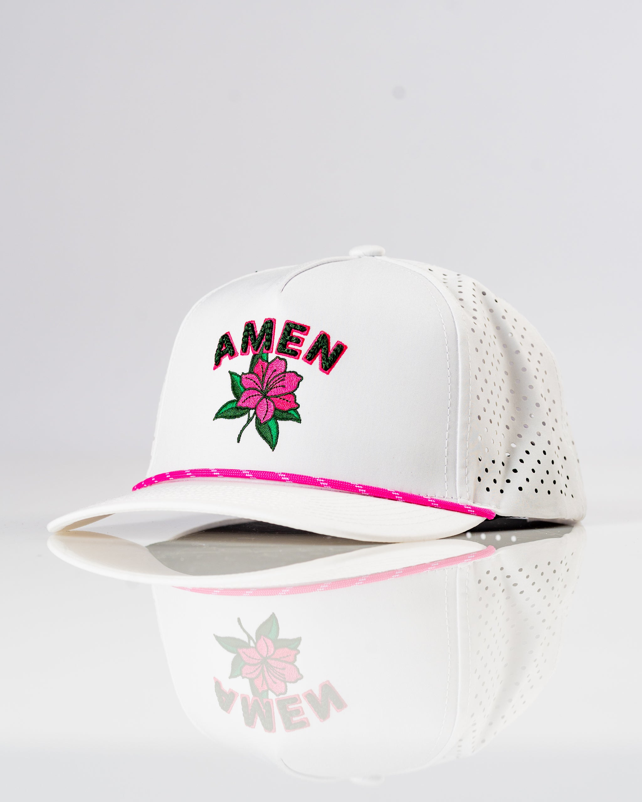White perforated rope hat featuring "AMEN" embroidered in pink with a floral design, perfect for stylish golfers.