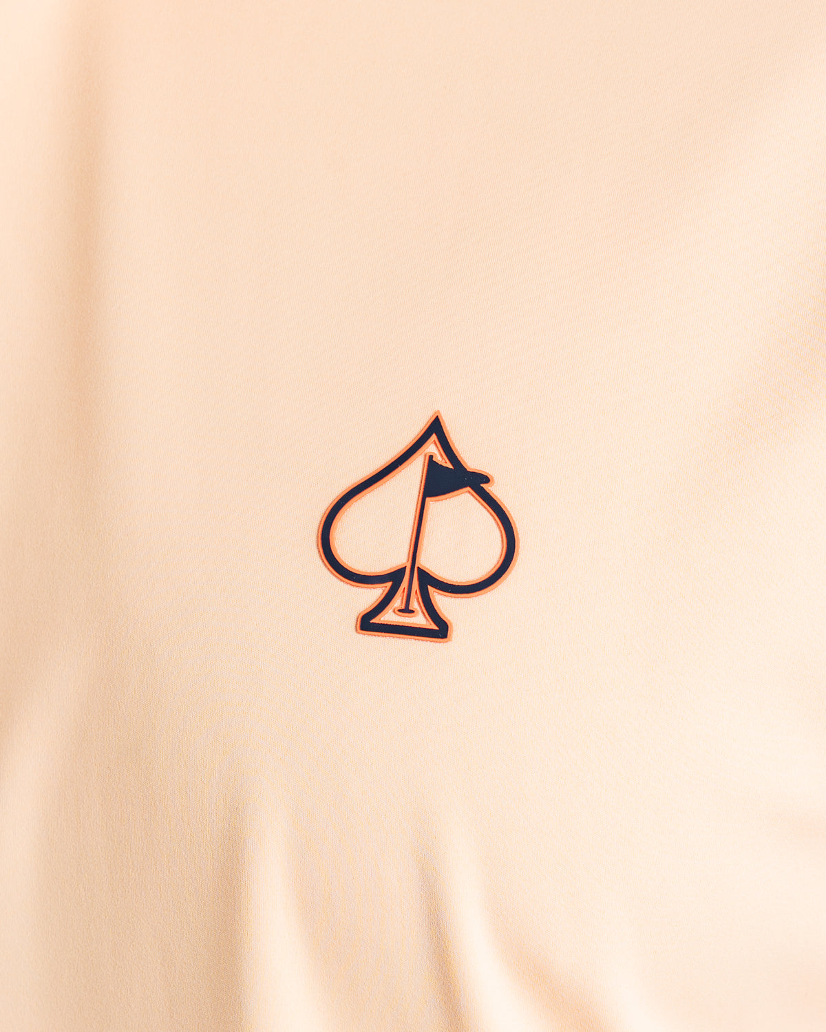 Close-up of the Performance Golf Hoodie in Autumn Leaves featuring a spade logo with a flag design.