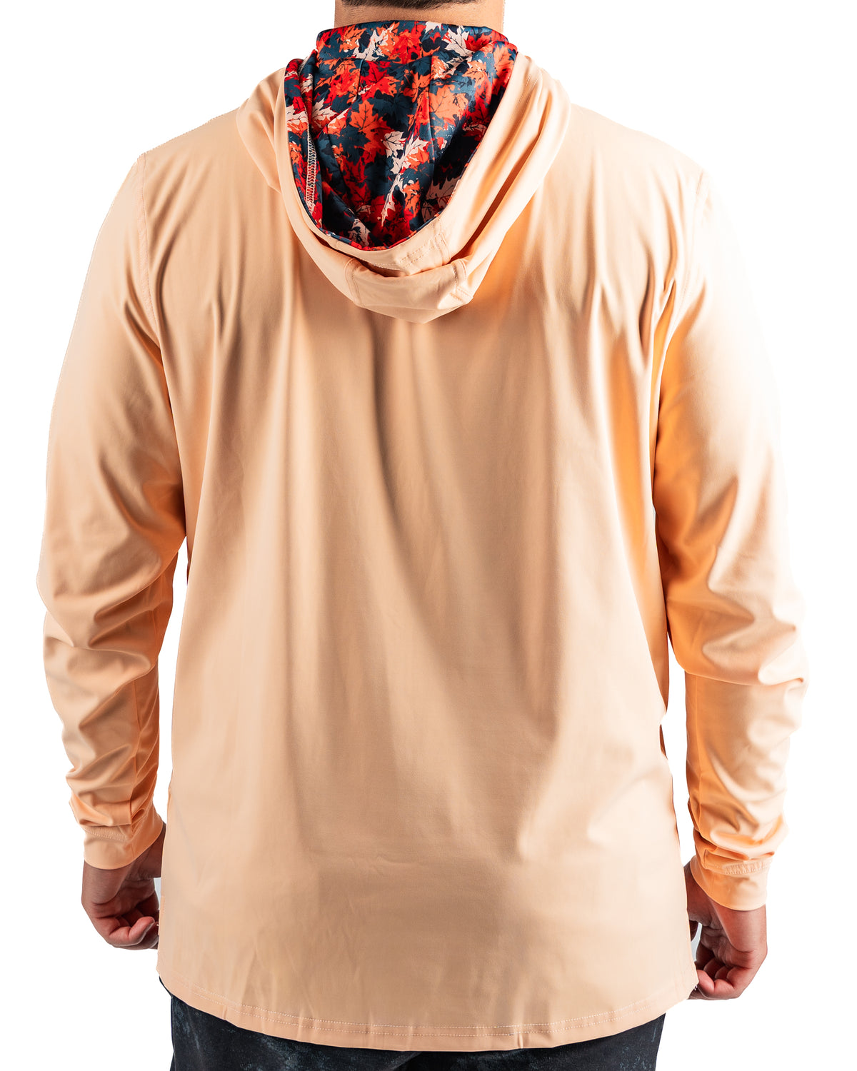 Men's performance golf hoodie in soft peach with a vibrant autumn leaves patterned hood, perfect for stylish comfort on the course.