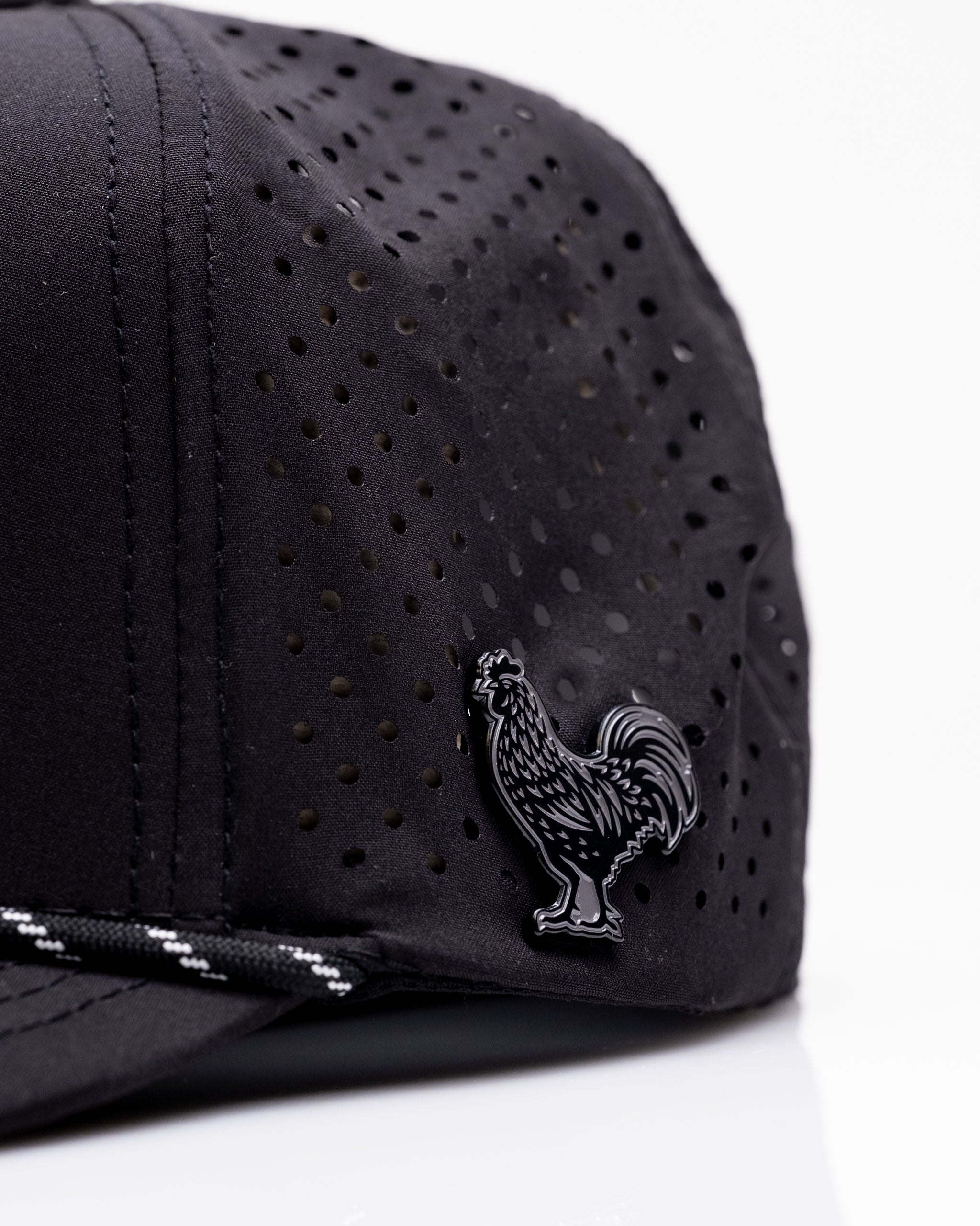 Perforated black rope hat featuring a sleek rooster emblem, designed for stylish golfers seeking standout accessories.