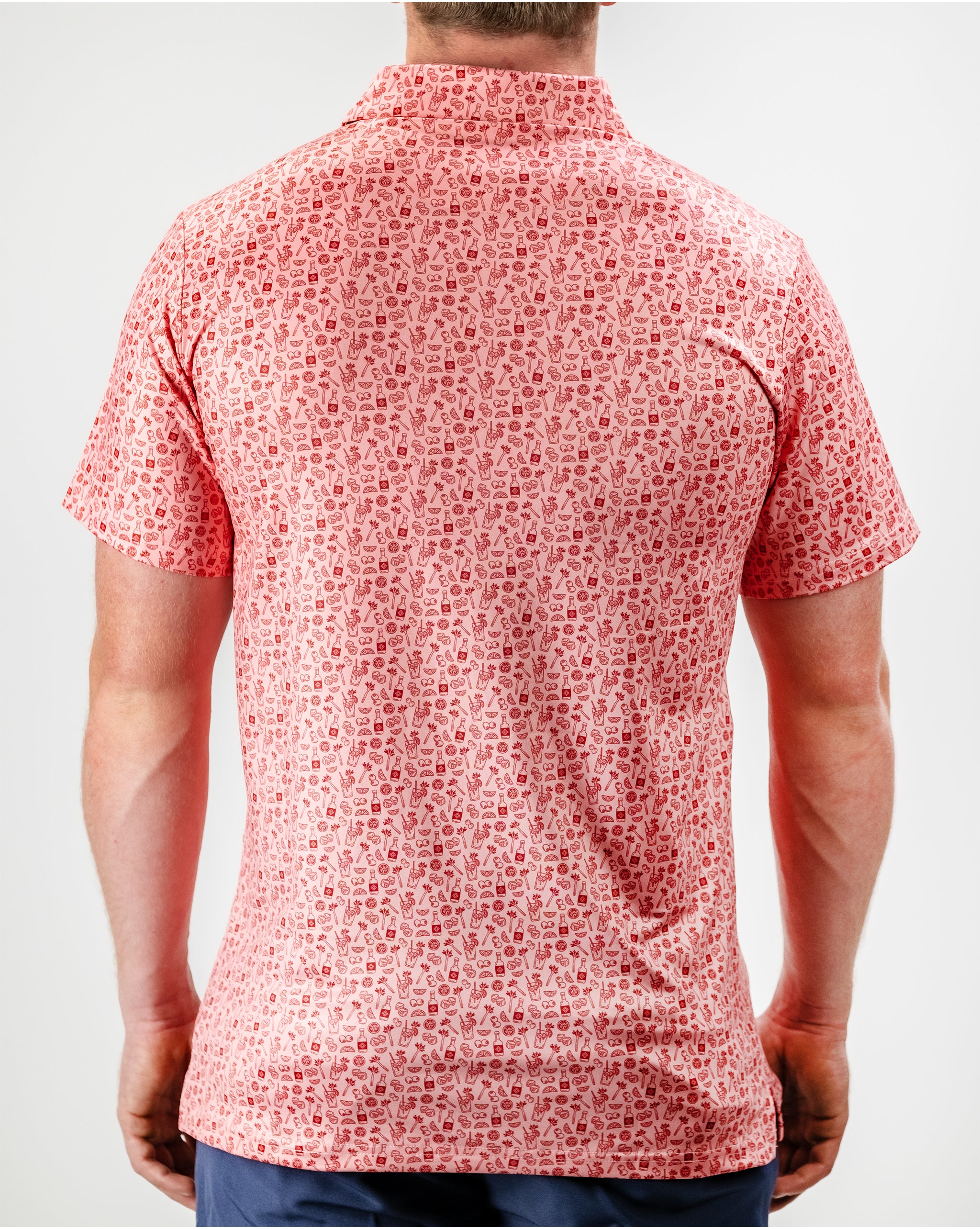 "Bloody Mary cocktail garnished with celery, olives, and spices, served in a glass with a colorful splatter design."