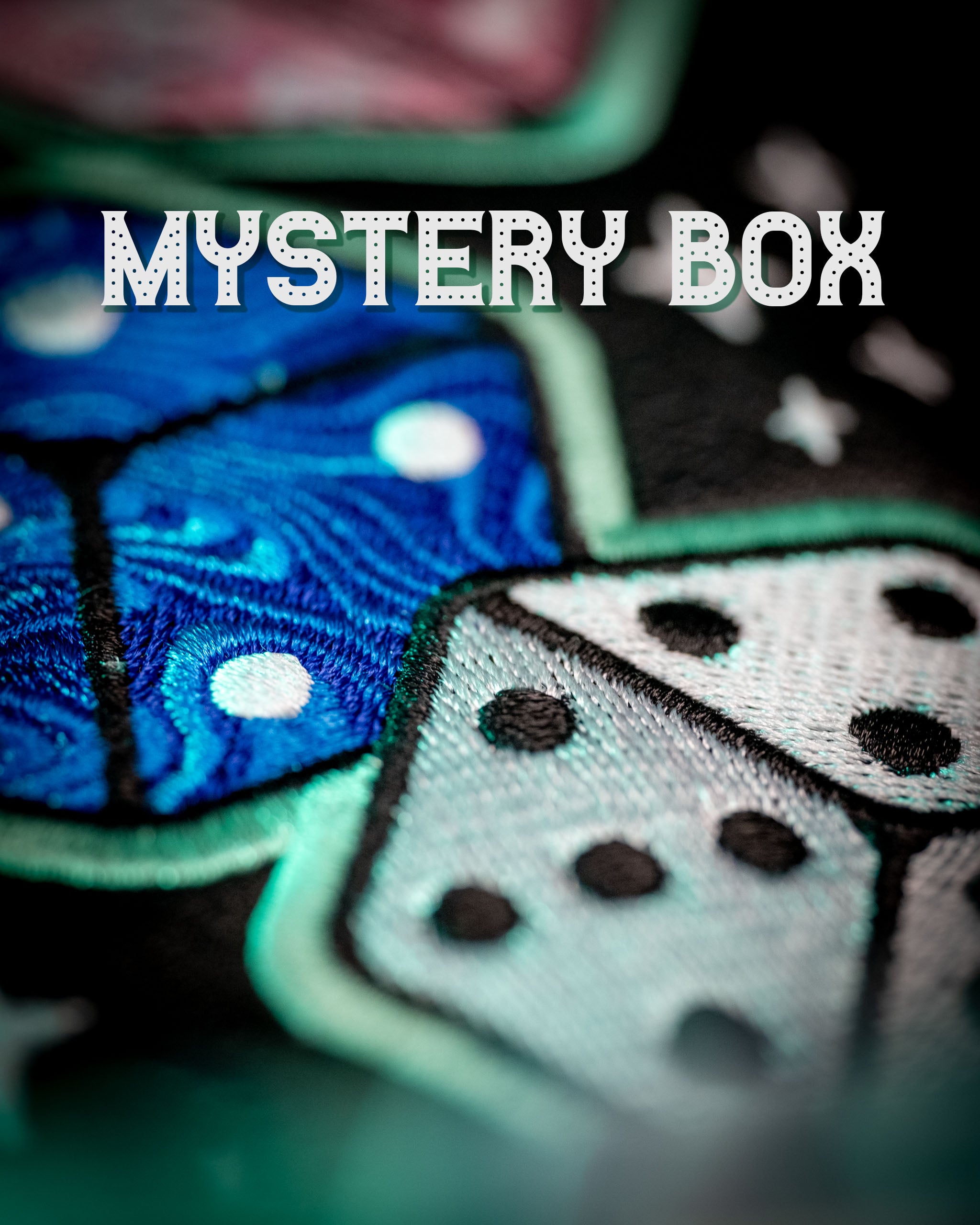 Colorful embroidered design featuring dice on a black background, highlighting the playful theme of the Mystery Box Backpack.