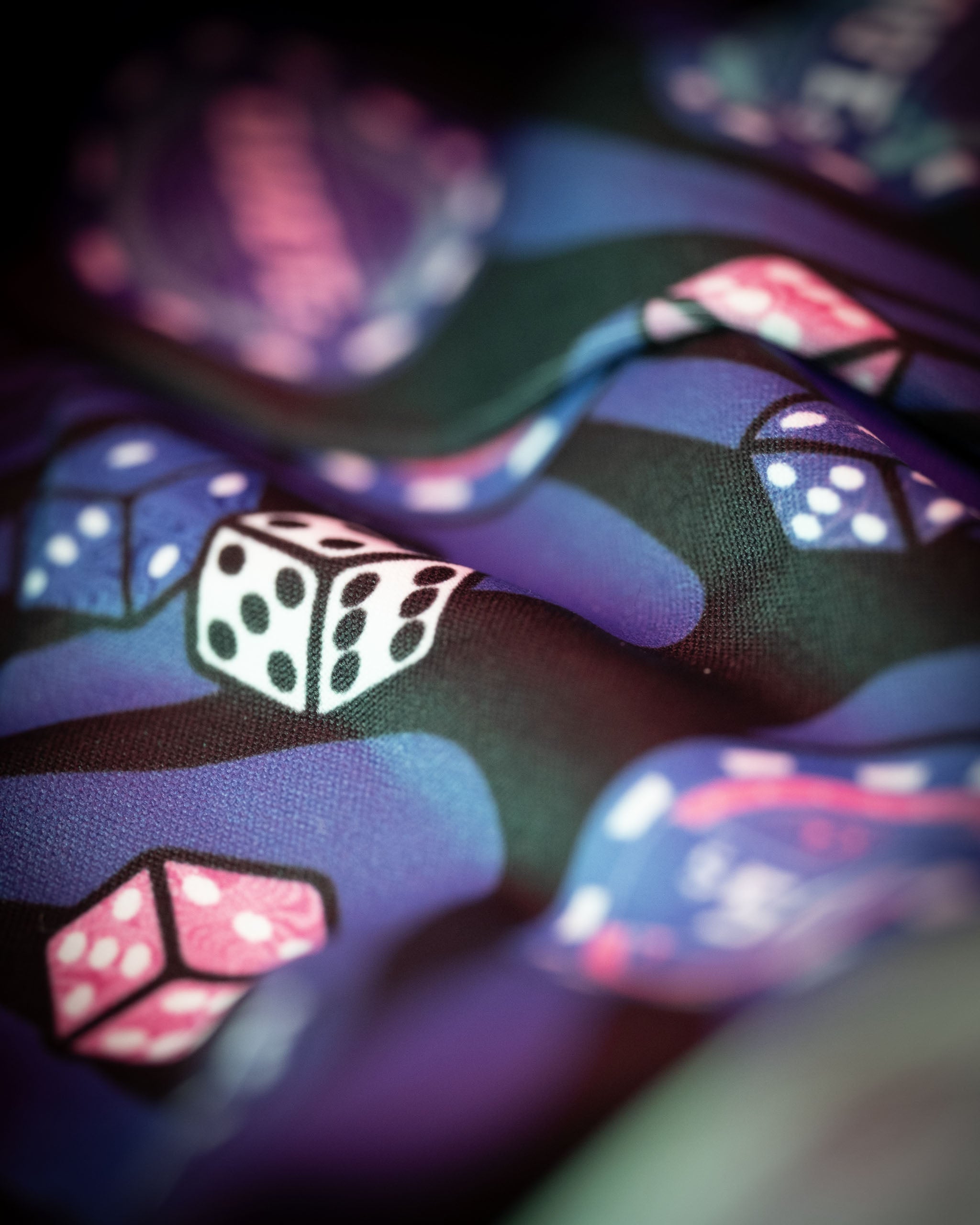 Colorful fabric featuring a playful design of dice and gaming elements, ideal for a unique Mystery Box Backpack.