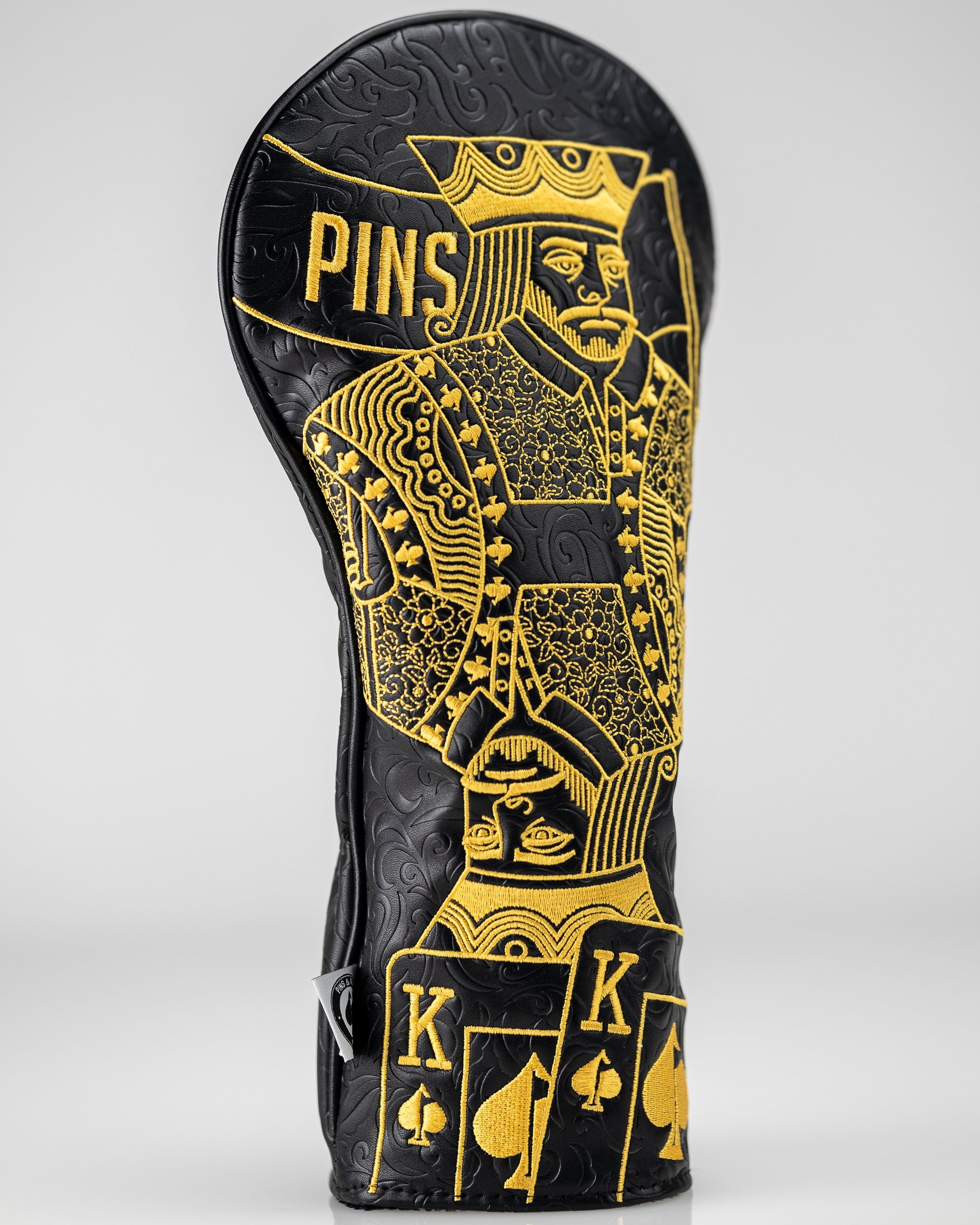 Black and gold King of Spades driver cover with intricate design, featuring a spade emblem prominently displayed.