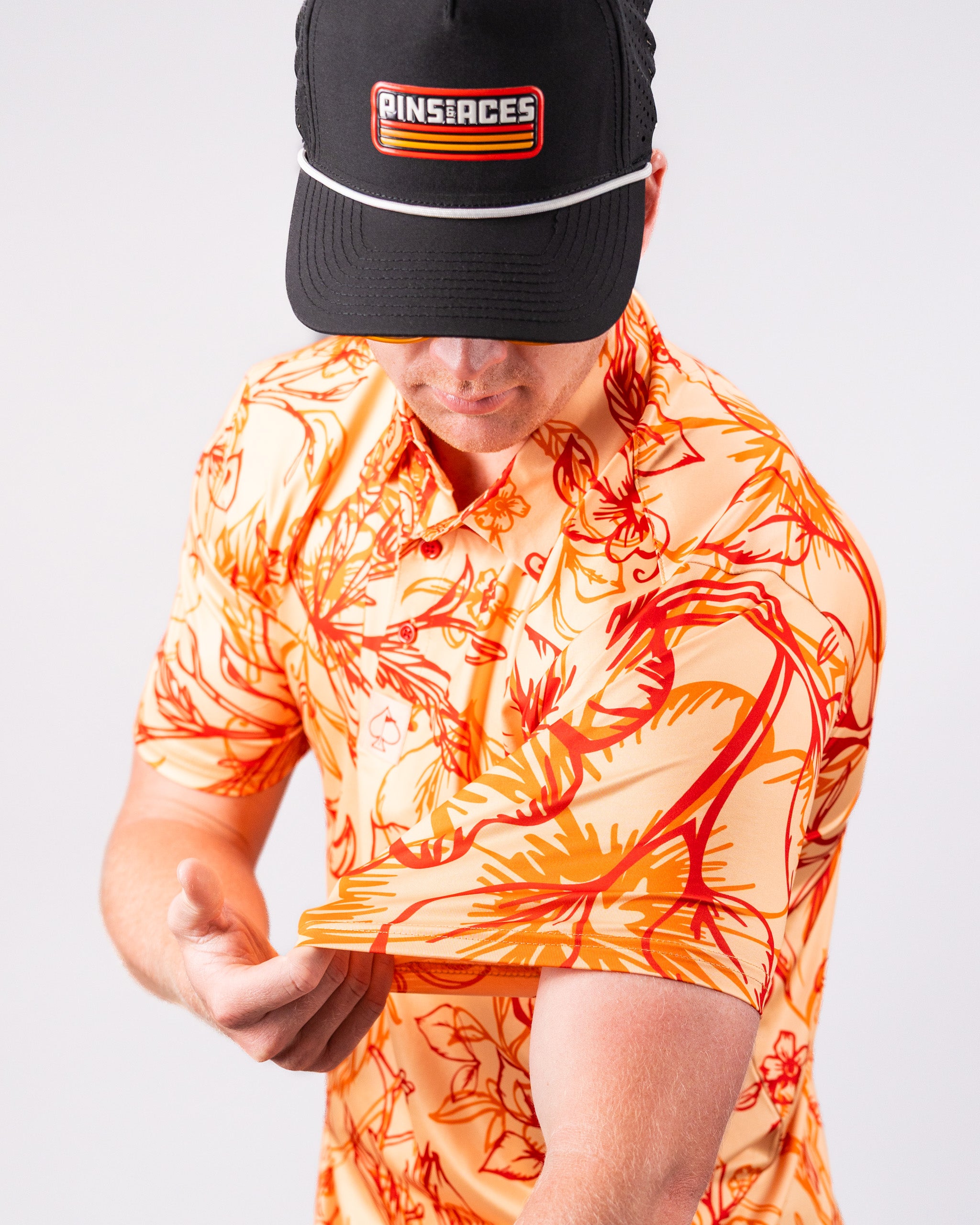 Cabo Sunburst polo shirt in vibrant orange, featuring a classic collar and short sleeves.